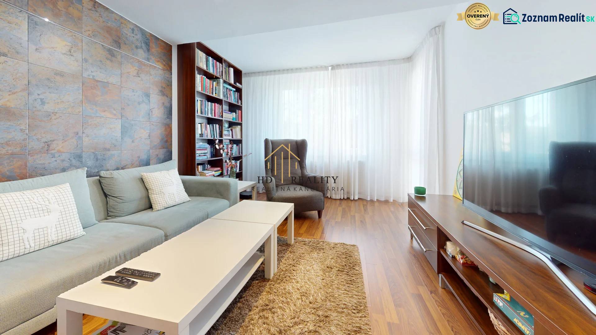 Predaj, 4izbový byt  Fončorda, Banská Bystrica - Obývacia izba v 4-izbovom byte s pohovkou, televízorom a podlahou s dreveným dekorom.