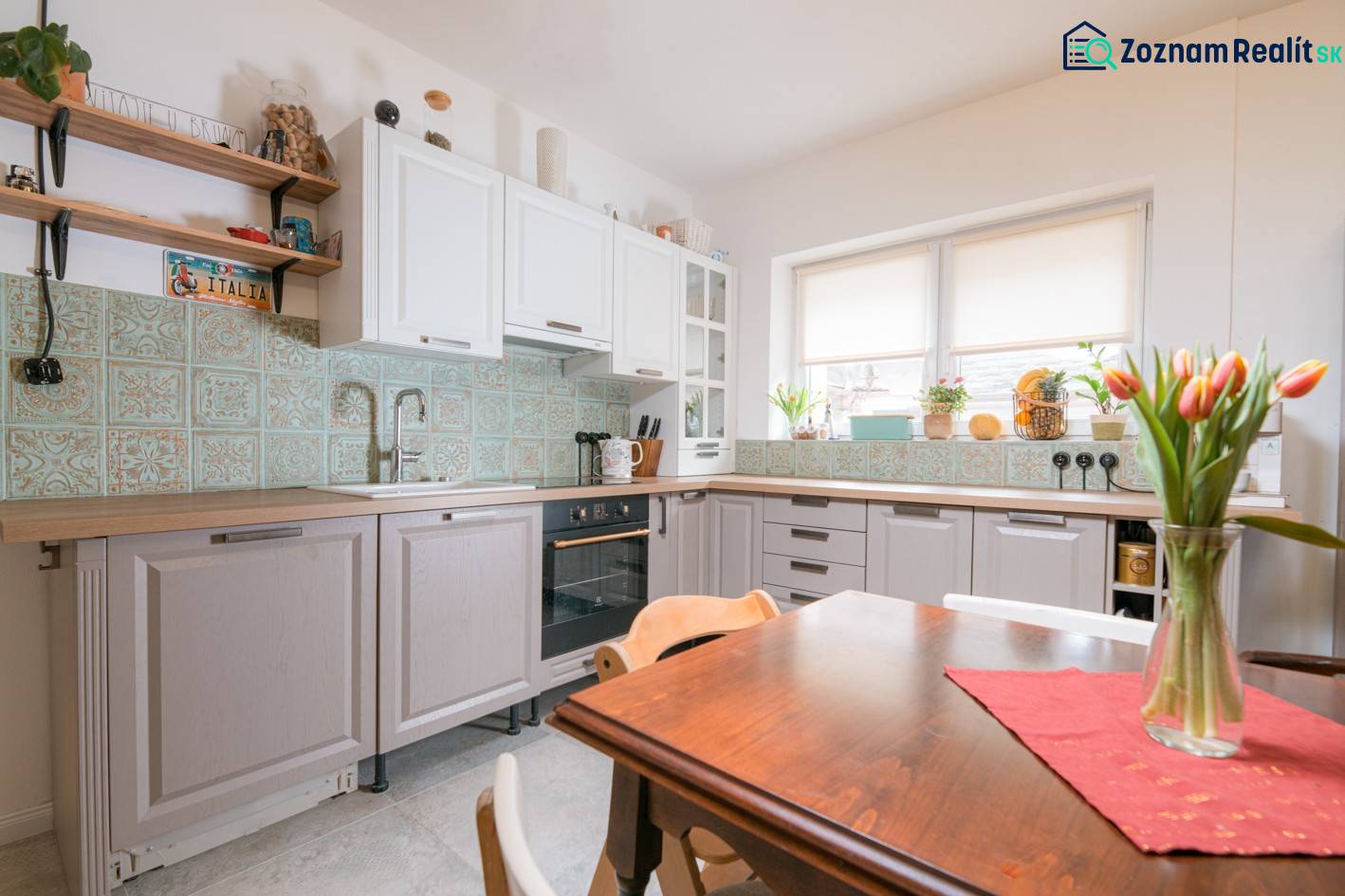 Na predaj zrekonštruovaný dom na Štefánikovej ulici, Trenčín - Rodinný dom: Kuchyňa s kvetinovou výzdobou a dekoratívnymi obkladačkami na stene.