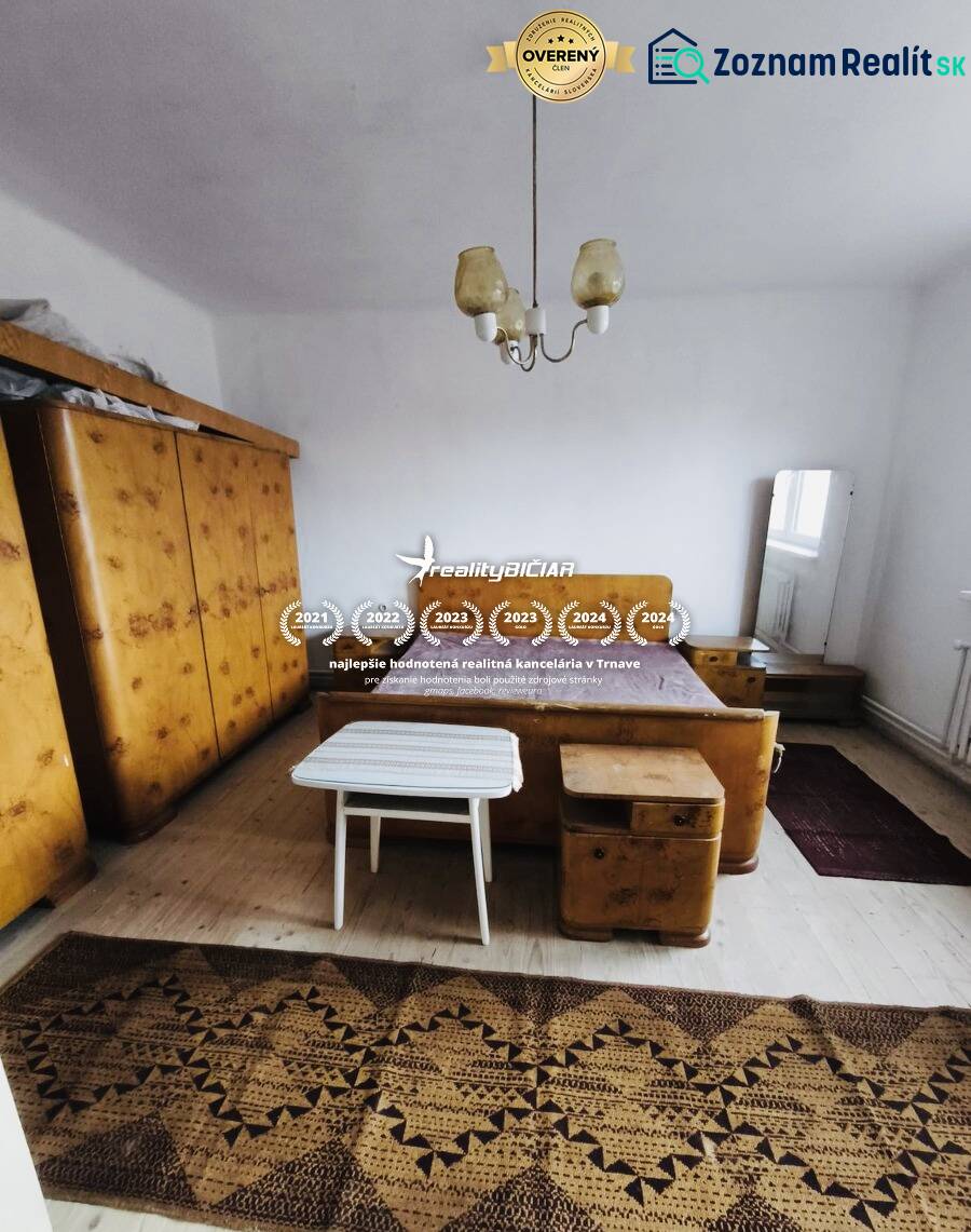 Predaj rodinného domu, Seredská, Seredská, Hlohovec - Spálňa v rodinnom dome s nábytkami, podlaha s dreveným dekorom, koberec, lampa.