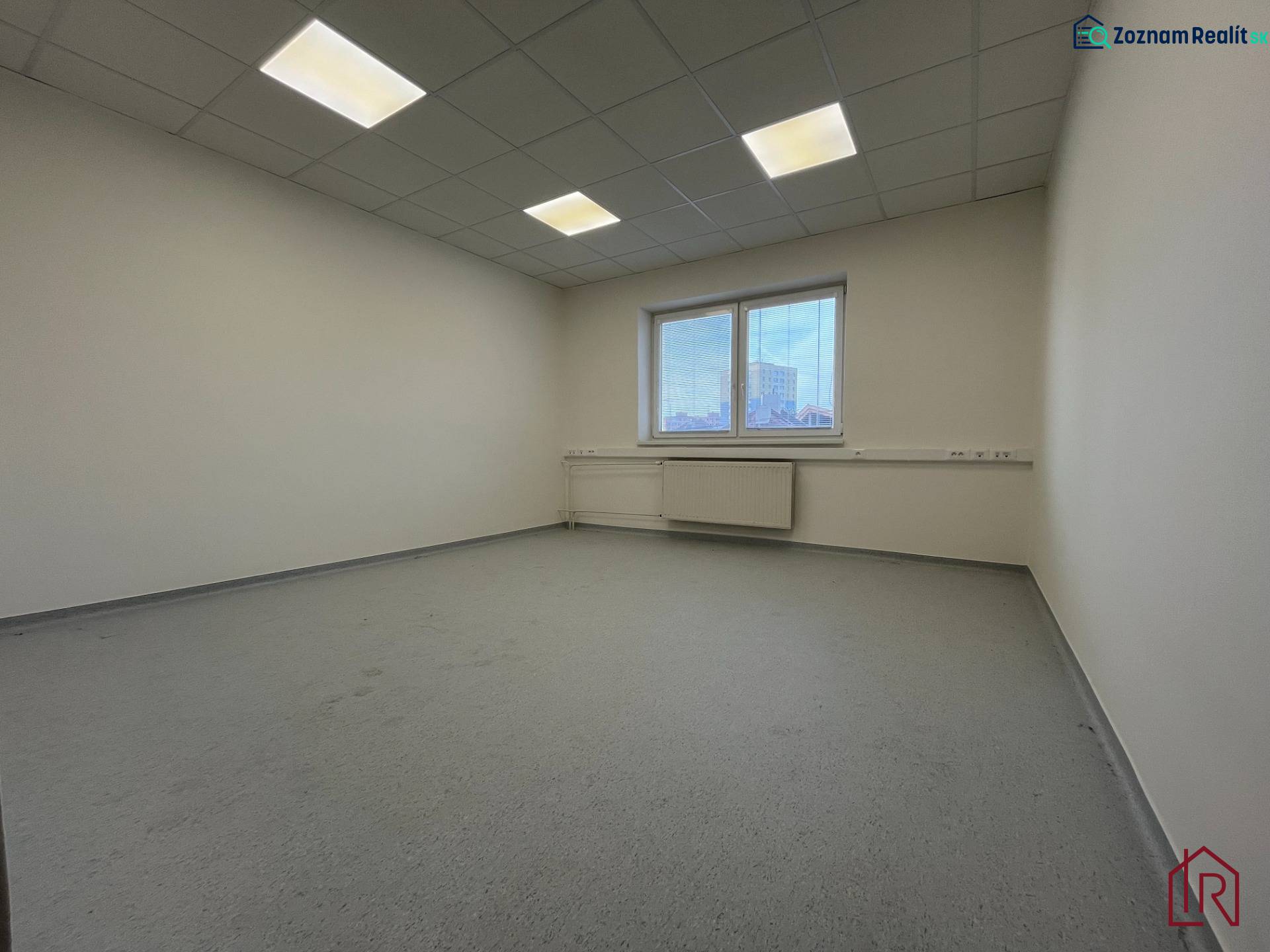 Investičná príležitosť: Polyfunkčná budova 1 000m², Košice-Staré mesto - Prázdna miestnosť so sivou podlahou a oknom v budove.