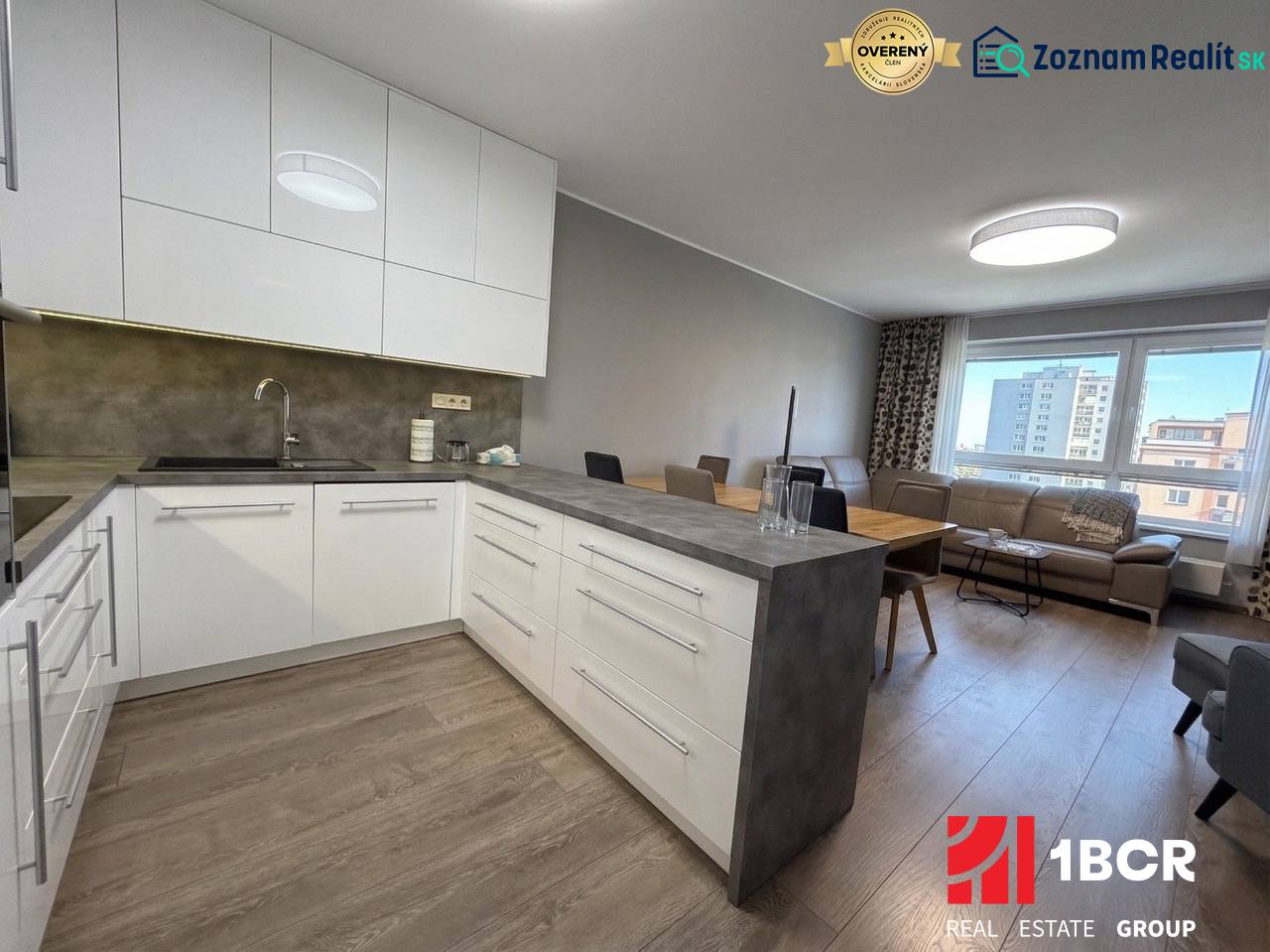 KOMPLETNE ZARIADENÝ 3-IZB. BYT, NOVOSTAVBA STEIN, BLUMENTÁLSKA UL. - Kuchyňa v 3-izbovom byte s bielymi skrinkami a podlahou s dreveným dekorom.