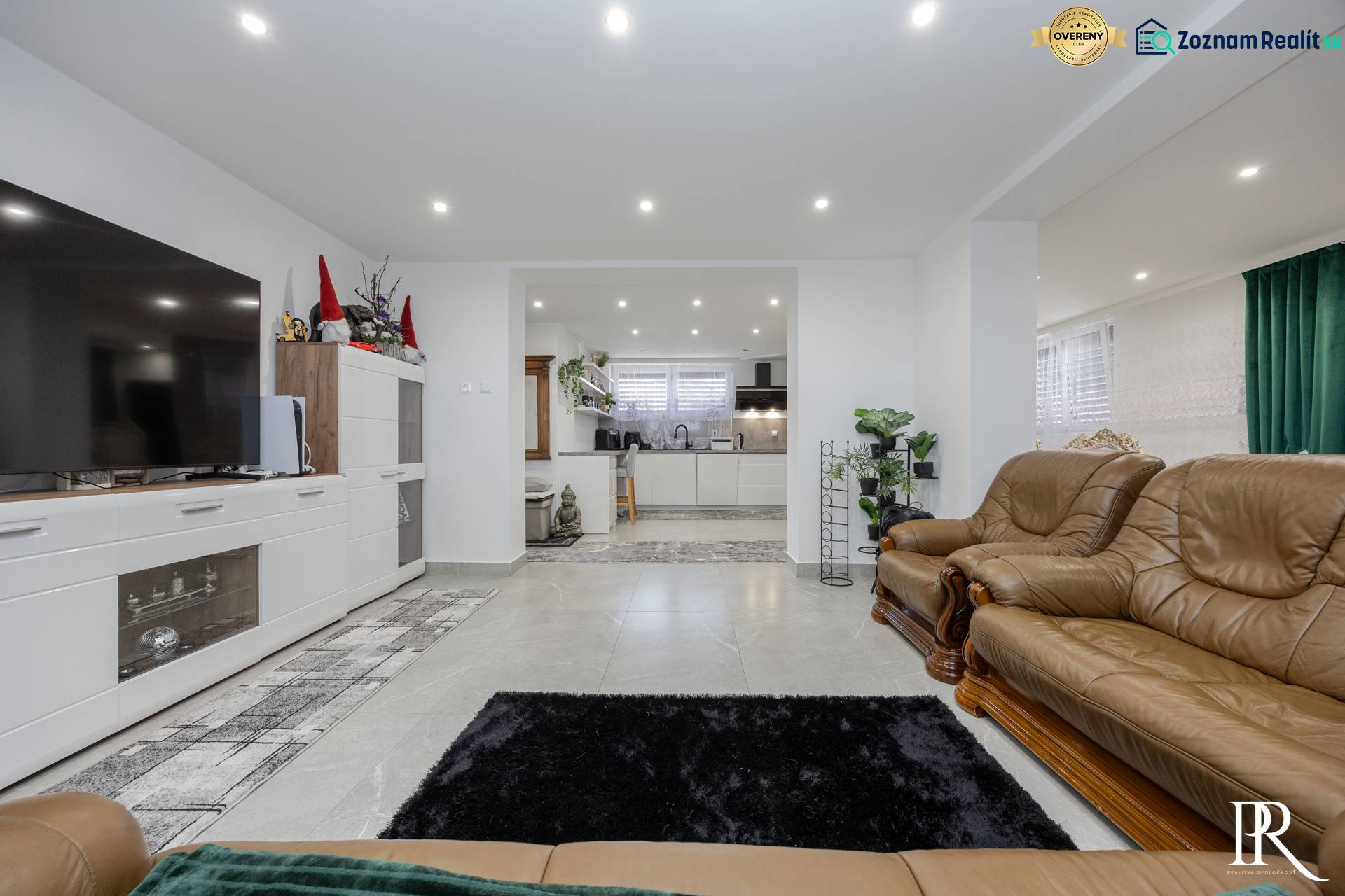 2-Generačný 9izb. RD s bazénom a veľkým pozemkom, Dvorníky - Obývacia izba s koženým nábytkom, dlažba a kuchynský kút v rodinnom dome.