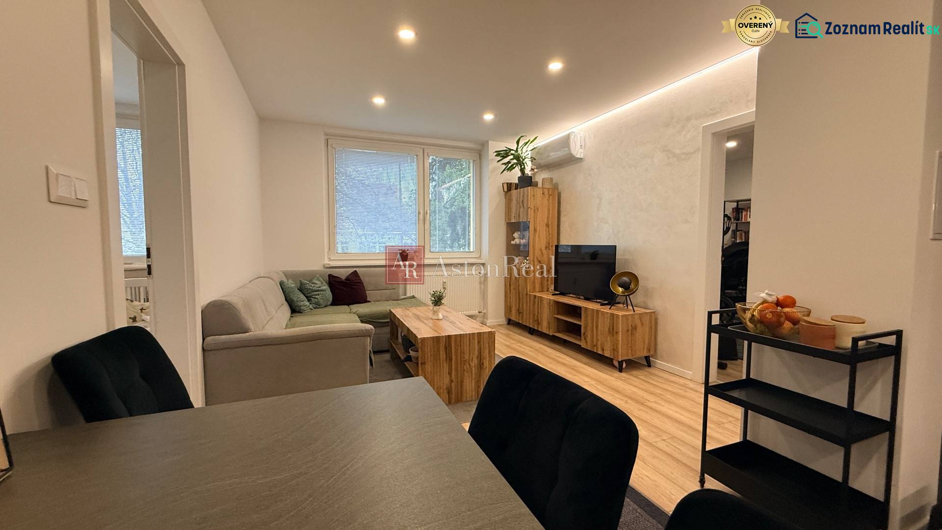 KOMPLETNE prerobený 4i byt s balkónom, 77m2 - ZÁTVOR - Obývacia izba so sedačkou, TV a dekorom na podlahe v 4-izbovom byte.