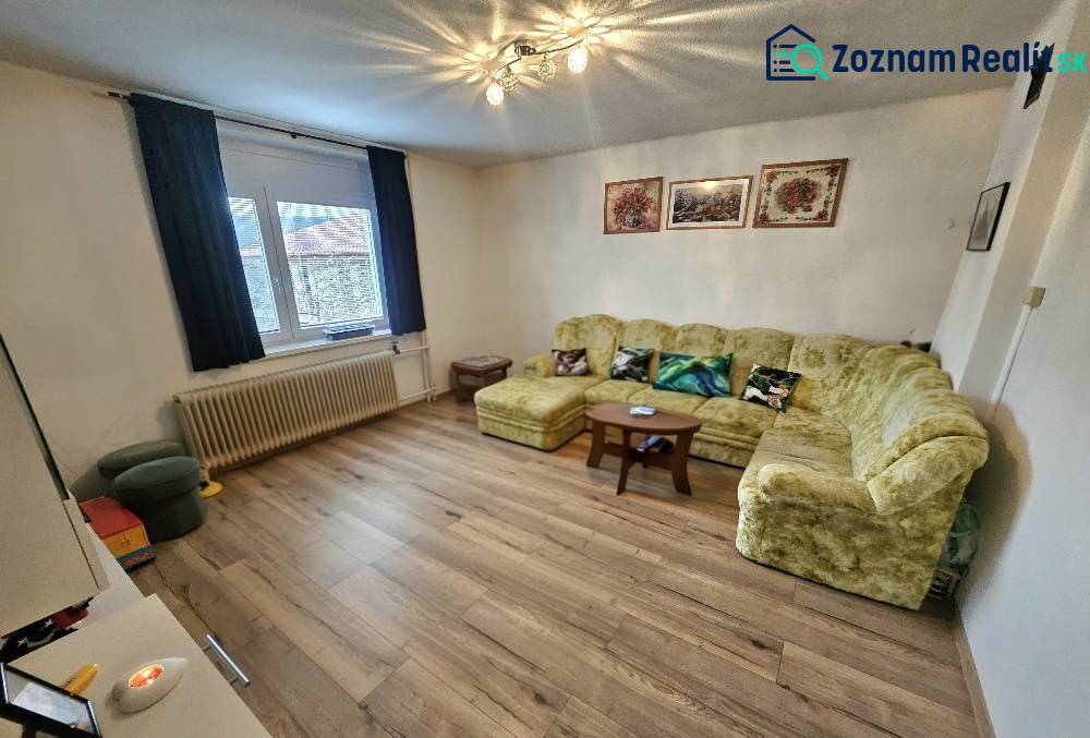 RODINNÝ DOM - HORNÉ OZOROVCE-POZEMOK 566 m2- 3,5 IZBOVÝ/ GARÁŽ - Obývacia izba v rodinnom dome s pohovkou, kreslami a podlahou s dreveným dekorom.