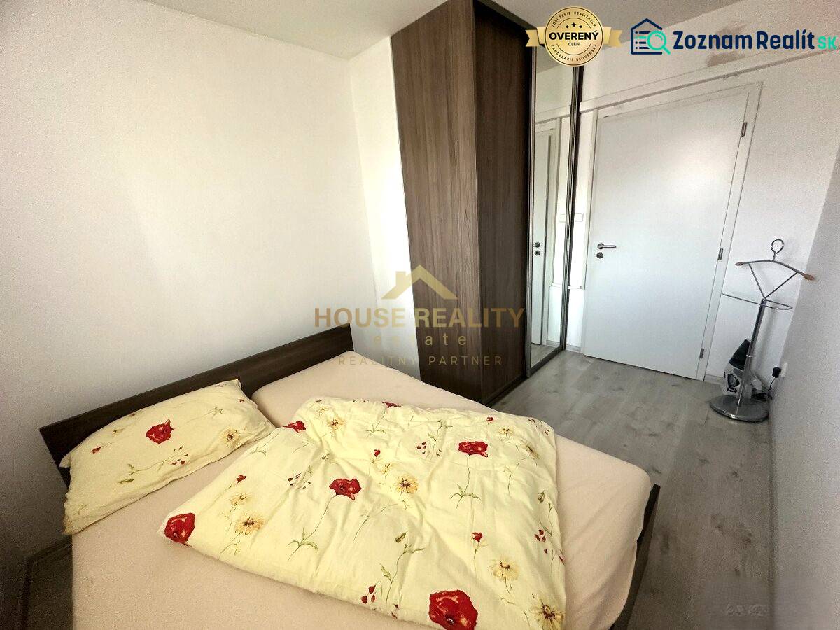 Prenájom pekný 2 izbový byt Šancová ulica, Bratislava III. Nové Mesto - Spálňa v 2-izbovom byte s posteľou, vstavanou skriňou a podlahou s dreveným dekorom.