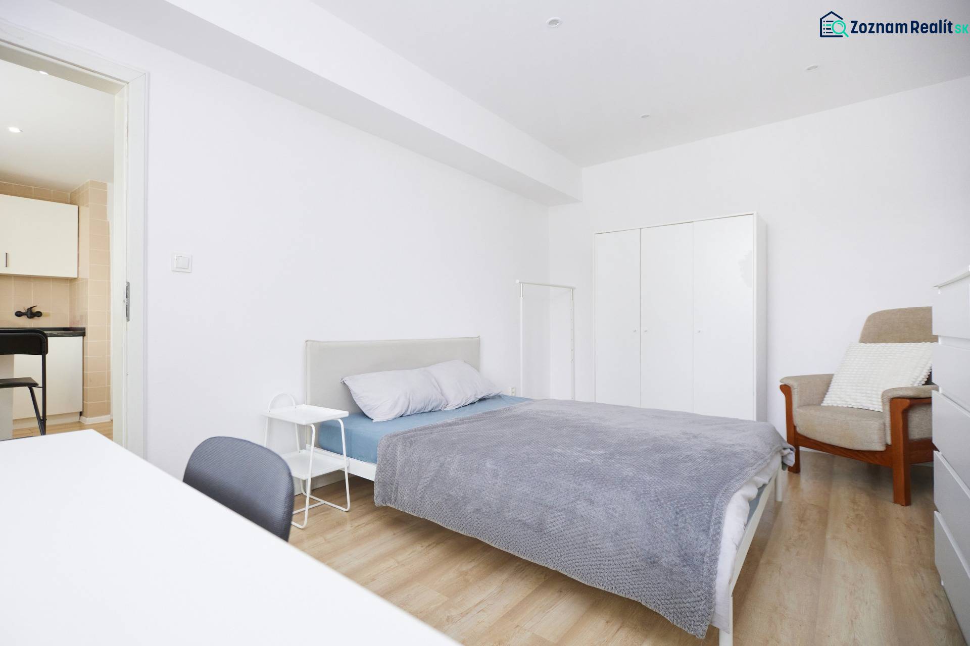 NA PREDAJ,2-IZBOVÝ TEHLOVÝ BYT,KOŠICE-SEVER,LOMNICKÁ UL. - Spálňa 2-izbového bytu s posteľou, skriňou a podlahou s dreveným dekorom.