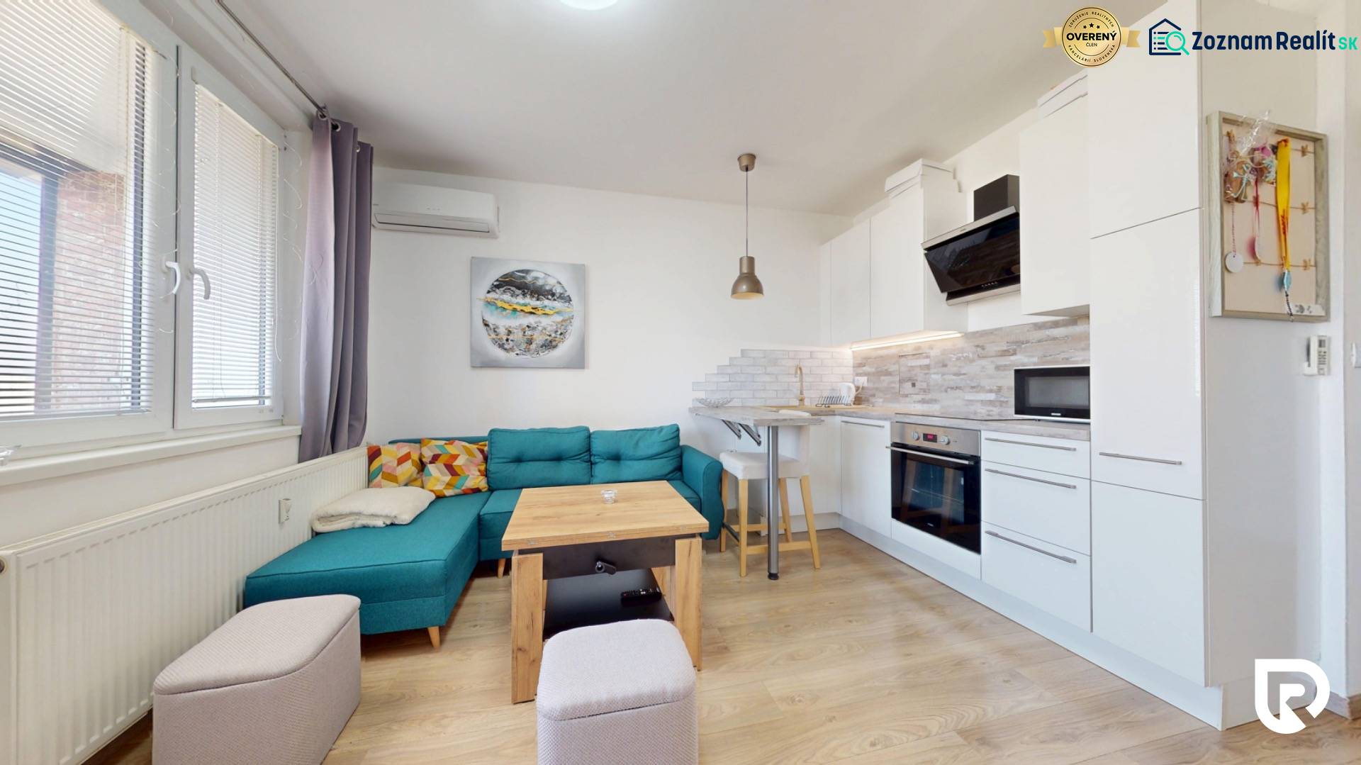 Pekný 2-izbový byt s lodžiou | investičná príležitosť | - Obývačka s kuchynským kútom, tyrkysovou sedačkou a podlahou s dreveným dekorom v 2-izbovom byte.