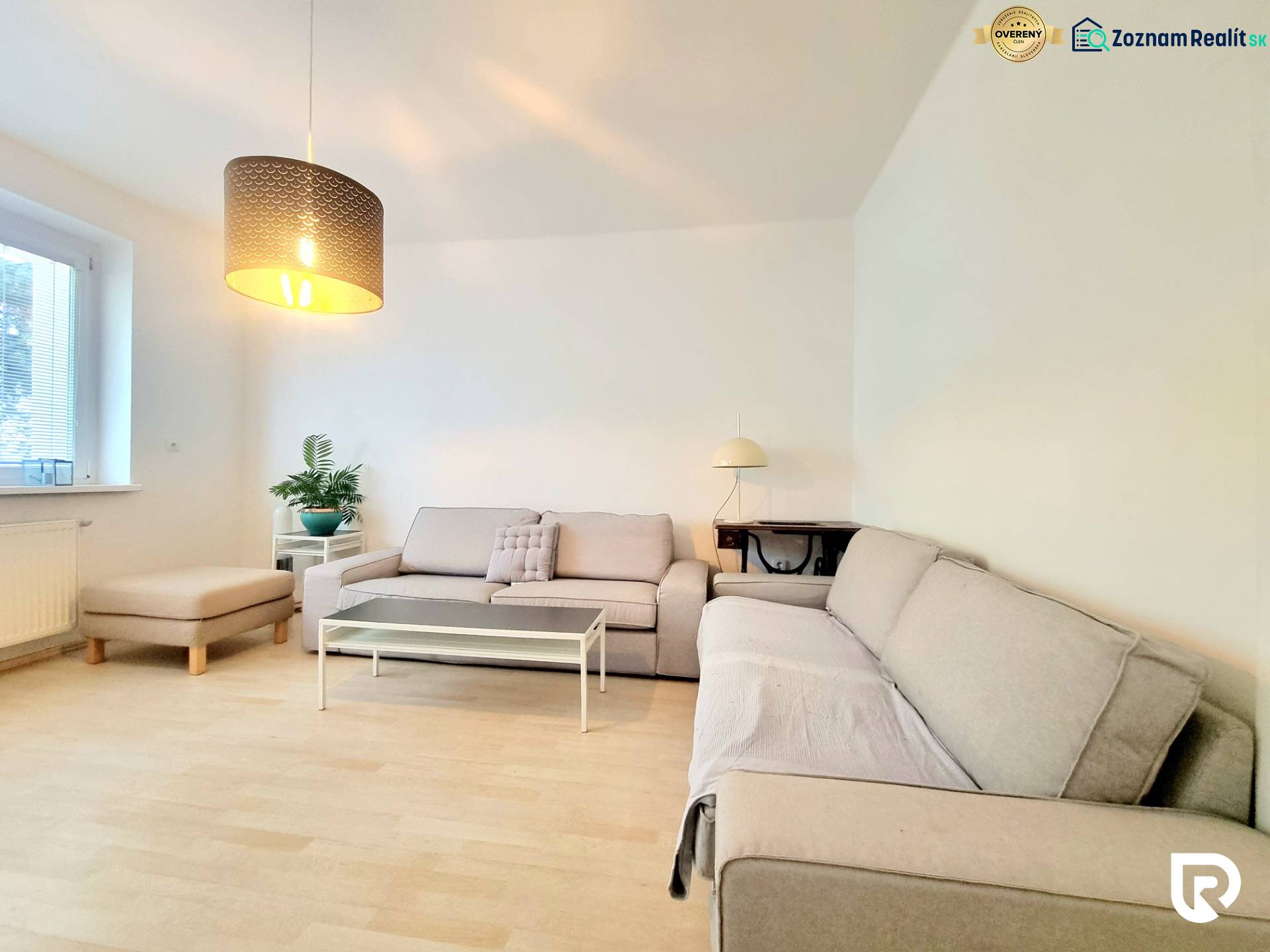 Príjemný a priestranný 3-izbový byt | 83 m² |  - Obývačka v 3-izbovom byte s pohovkou, stolíkom a podlahou s dreveným dekorom.