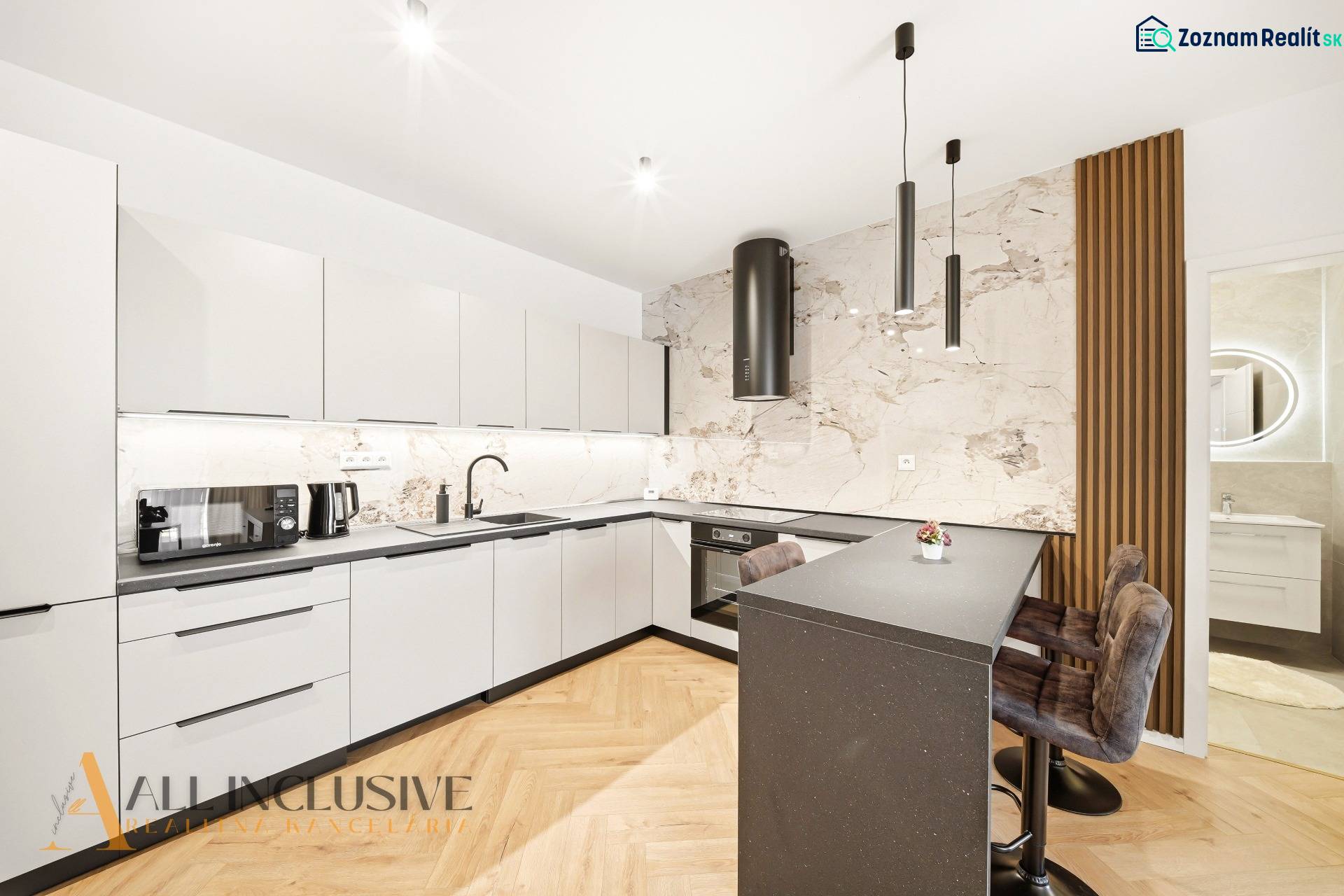 Na prenájom 2-izb. byt s terasou, Dun. Streda -Florida - Kuchyňa s bielymi skriňami, ostrovčekom a podlahou s dreveným dekorom v 4-izbovom byte.