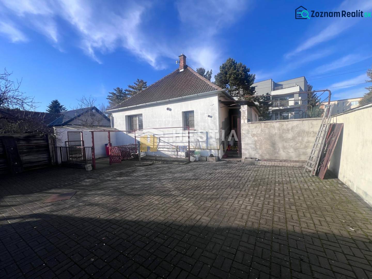 Na predaj rodinný dom, gastro prevádzka – Senica, Robotnícka ulica - Dvorný exteriér s betónovou dlažbou a rodinným domom v meste Senica, predstavený ako gastro priestory.