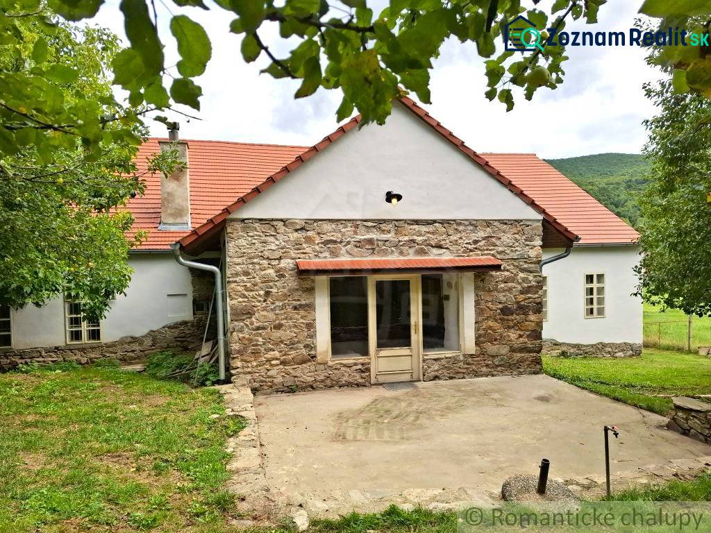 Unikátny meštiansky dom s veľkou záhradou – história, štýl a potenciál - Rodinný dom v Dobroči s kamennou fasádou, tradičnou strechou a príjemnou záhradou.
