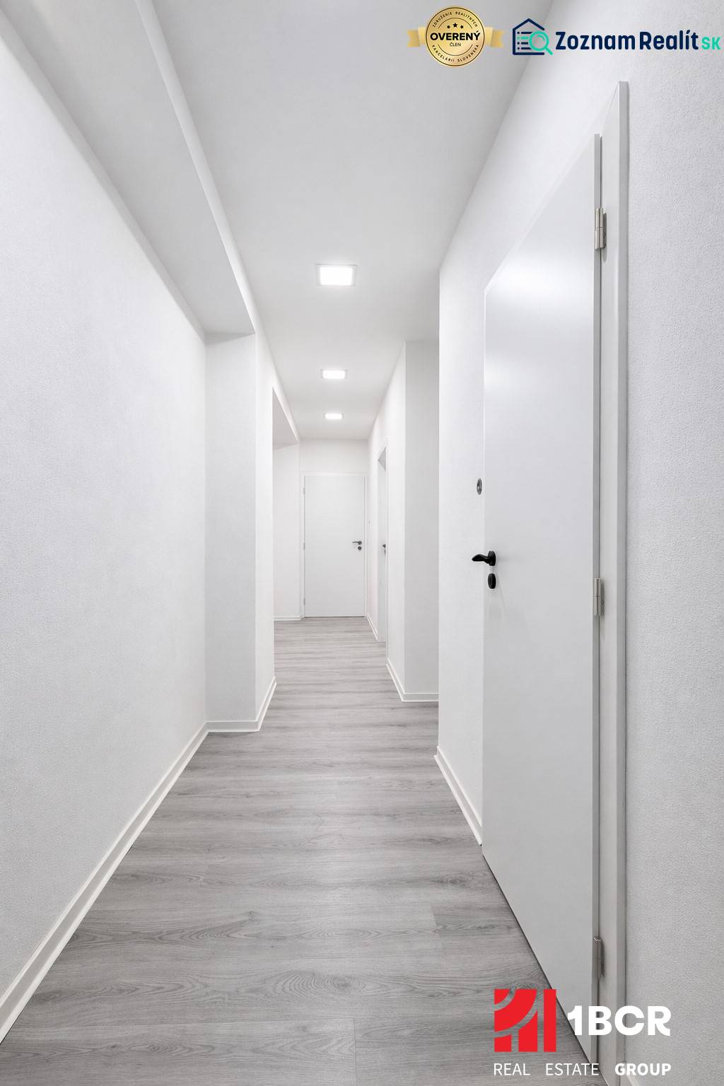 NOVÁ KOMPLET. REK., 3–IZB. BYT, PIVNICA, BALKÓN, DUKELSKÁ, BERNOLÁKOVO - Chodba s bielymi stenami a podlahou s dreveným dekorom v 3-izbovom byte.