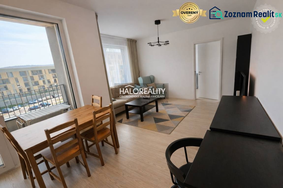 Predaj, dvojizbový byt Bratislava Devínska Nová Ves,... - Obývačka v 2-izbovom byte s balkónom, podlahou s dreveným dekorom, jedálenským stolom.
