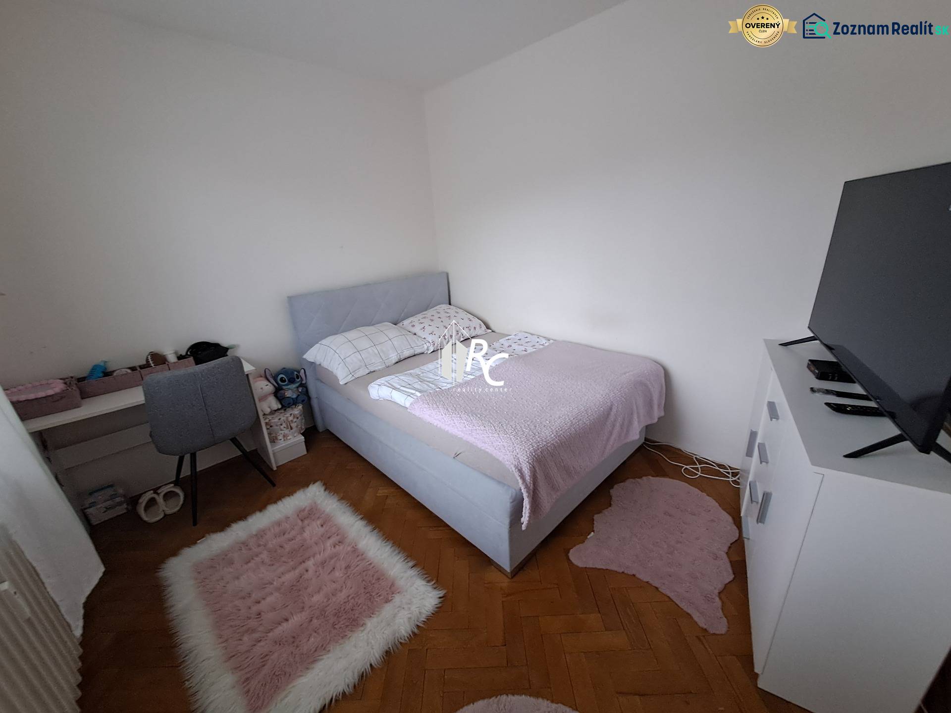 Predaj čiastočne prerobený 3 izbový byt Martin Sever - Spálňa v 3-izbovom byte s podlahou s dreveným dekorom, posteľou a televízorom na skrinke.