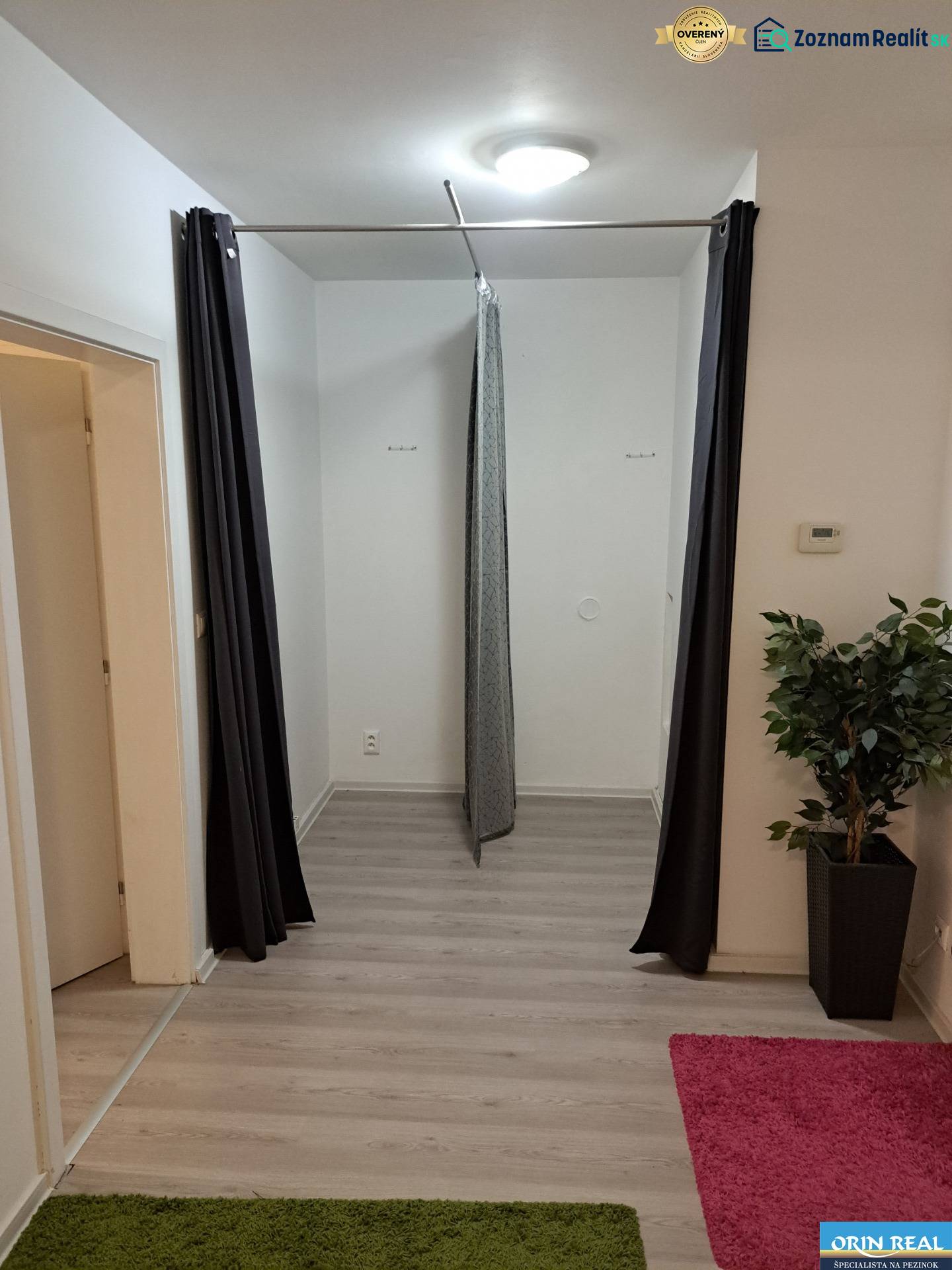 PREDAJ NEBYTOVÉHO PRIESTORU TAKMER V CENTRE PEZINKA - Chodba so závesom, na ulici Hrnčiarska, kancelárie, biele steny a farebné koberce.