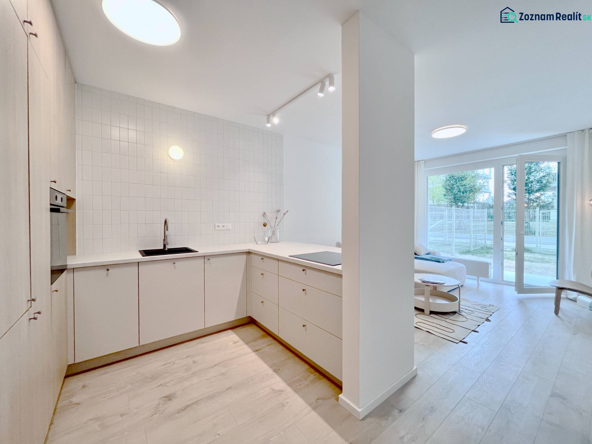 NUERA︱NOVÝ RUŽINOV - kompletne zariadený 2-izbový apartmán so záhradou - Kuchyňa s bielymi skrinkami, podlaha s dreveným dekorom, otvorený priestor v 2-izbovom byte.