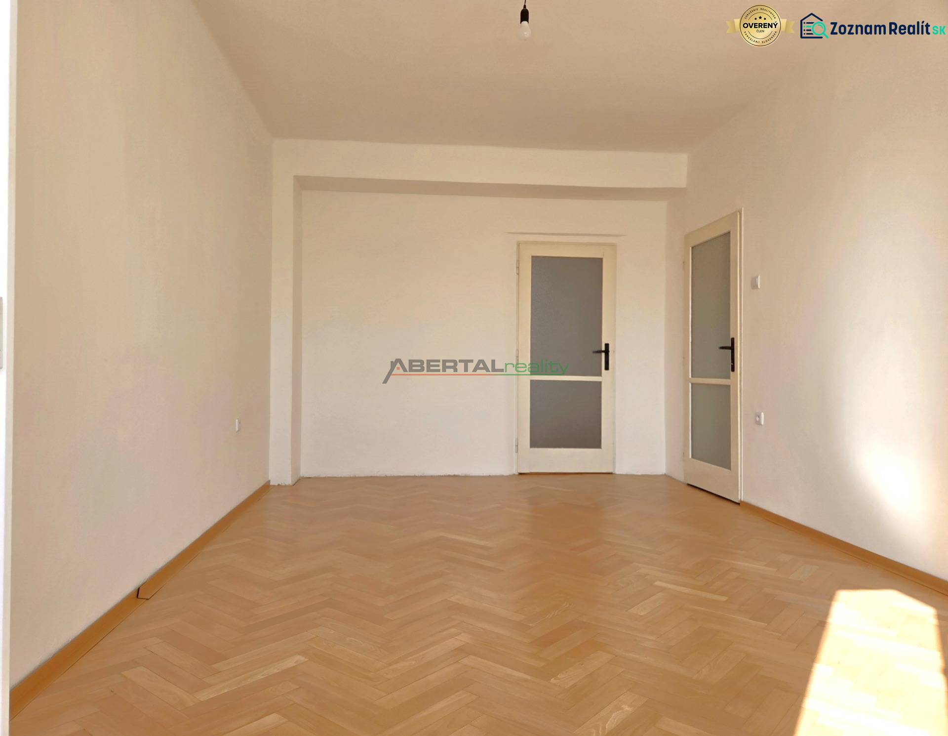 Predaj - 3 izbový byt,  69 m2, balkón,  ul.ČSA, KE - Staré Mesto - Izba v 3-izbovom byte má podlahu s dreveným dekorom a biele steny.