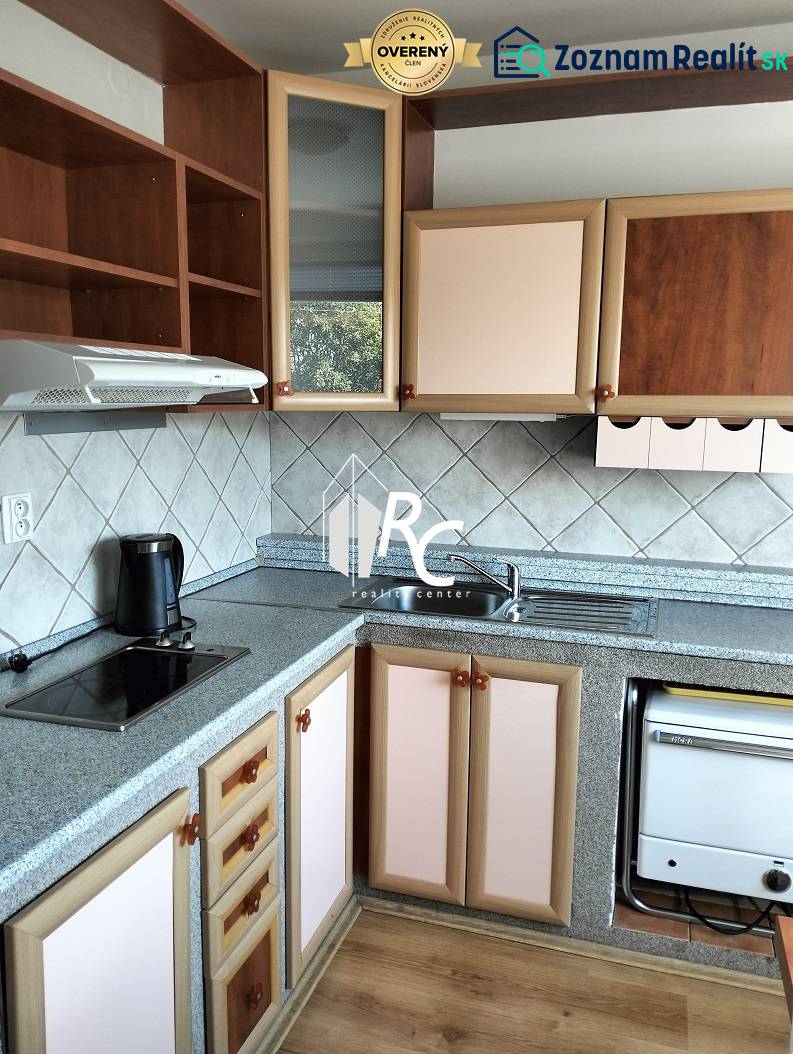 Prenájom 1-izbového bytu s energiami, Martin - Jahodníky - Kuchyňa v 1-izbovom byte s kuchynskou linkou a podlahou s dreveným dekorom.
