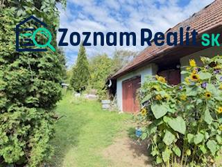 Rodinný dom (chalupa) na veľkom pozemku, Krúd - Bodovka - Rodinný dom v Krivosúd-Bodovke s červenými dverami a slnečnicami na záhrade.