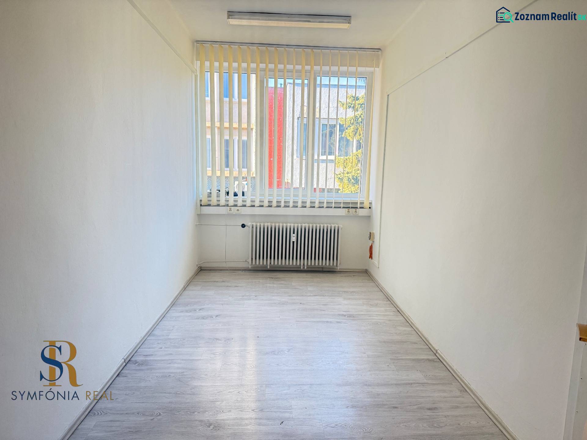 Prenájom centrum Galanty - Úzka kancelária s podlahou s dreveným dekorom a veľkým oknom.