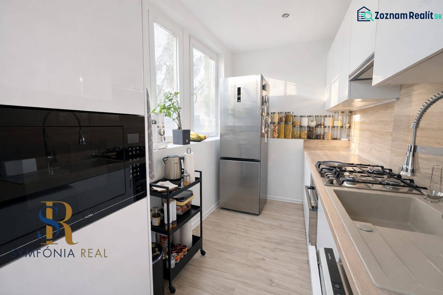 NOVINKA - Priestranných 74 m² v štýlovo zariadenom byte - Kuchyňa v 3-izbovom byte s podlahou s dreveným dekorom a modernými spotrebičmi.
