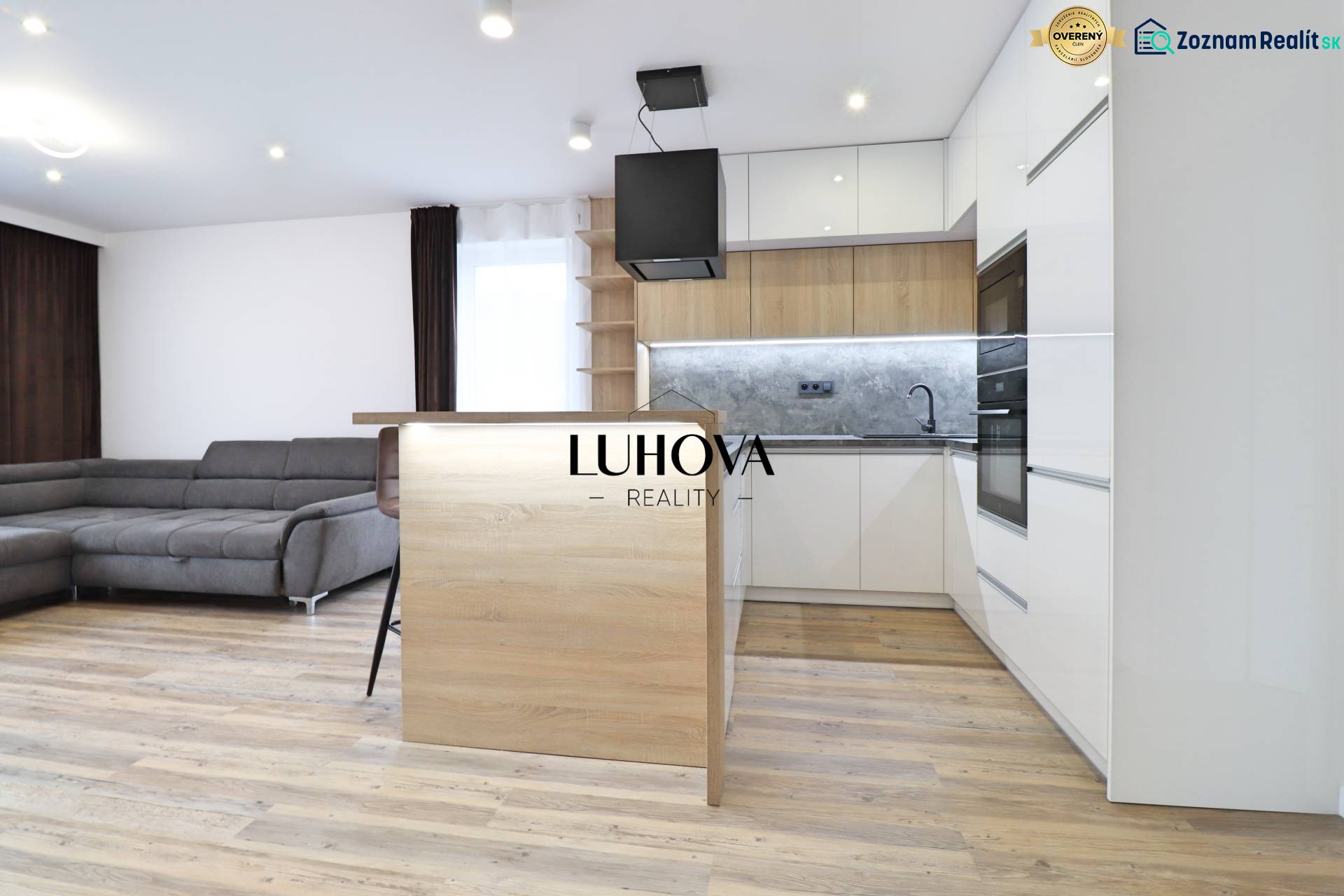 Na PRENÁJOM_v NOVOSTAVBE krásny 3-izbový byt s parkovacím státím - Obývačka s kuchyňou a podlahou s dreveným dekorom v 3-izbovom byte.