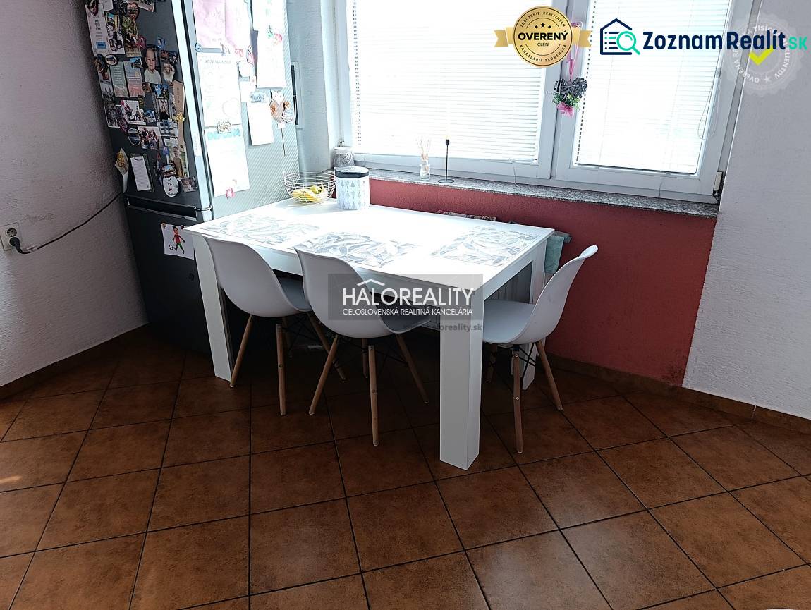 Prenájom, dvojizbový byt Nováky - Kuchyňa 2-izbového bytu s jedálenským stolom, bielymi stoličkami a oknom.