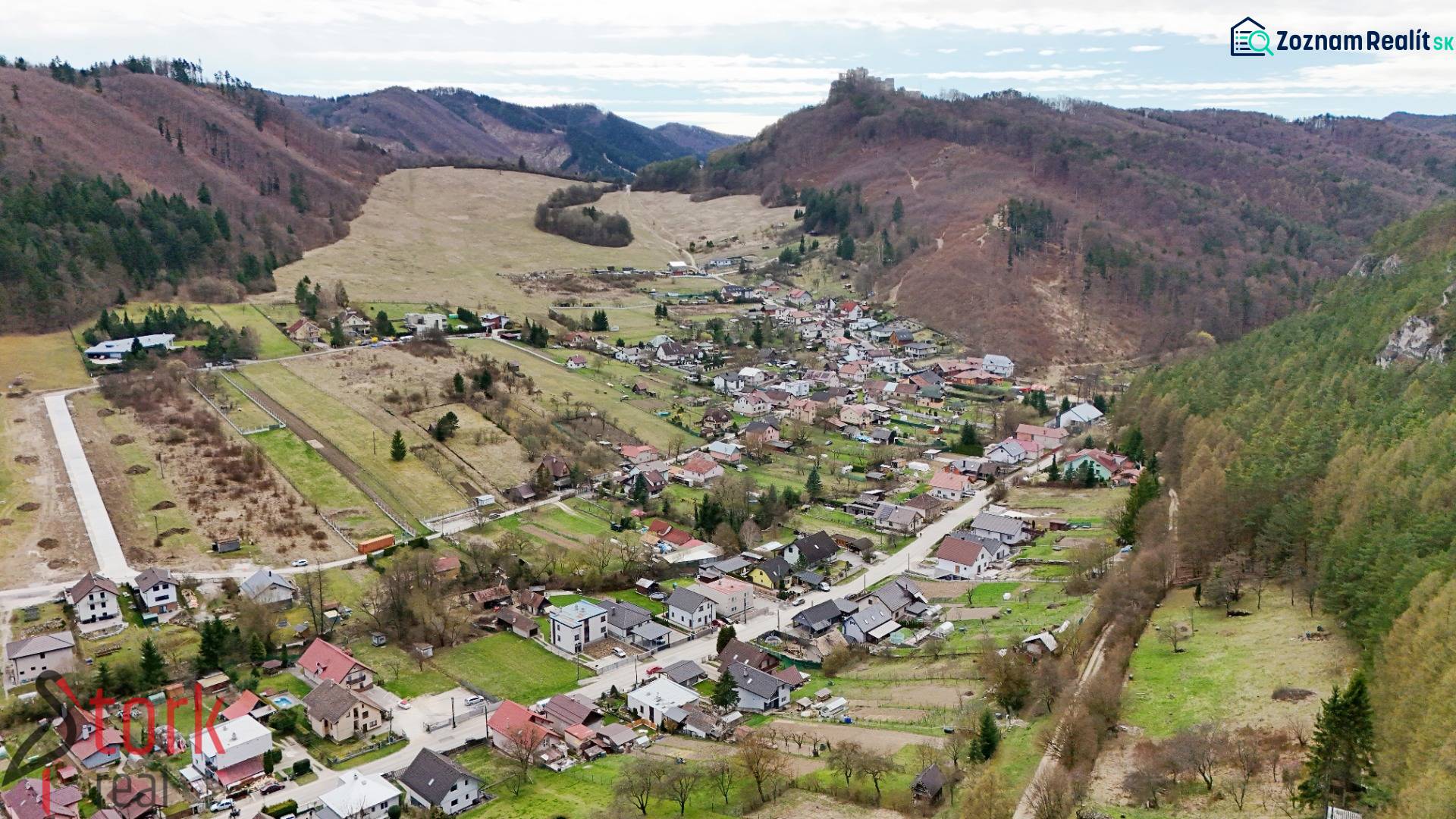Slnečný stavebný pozemok s VÝHĽADOM NA HRAD - obec Lietava - Letecký pohľad na dedinu v obklopení horskej krajiny v Lietave, na ulici Majer, Pozemky - bývanie.