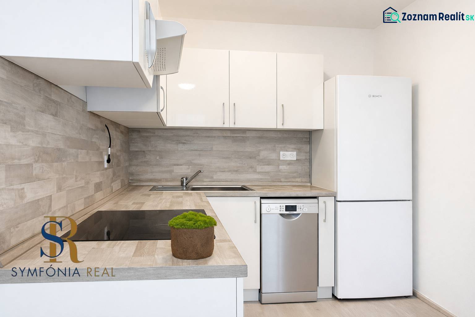 NOVOSTAVBA (2019) + PARKOVANIE | 2-izbový byt 69 m² – Bratislava - Kuchyňa s bielymi skrinkami, spotrebičmi a podlahou s dreveným dekorom v 2-izbovom byte.