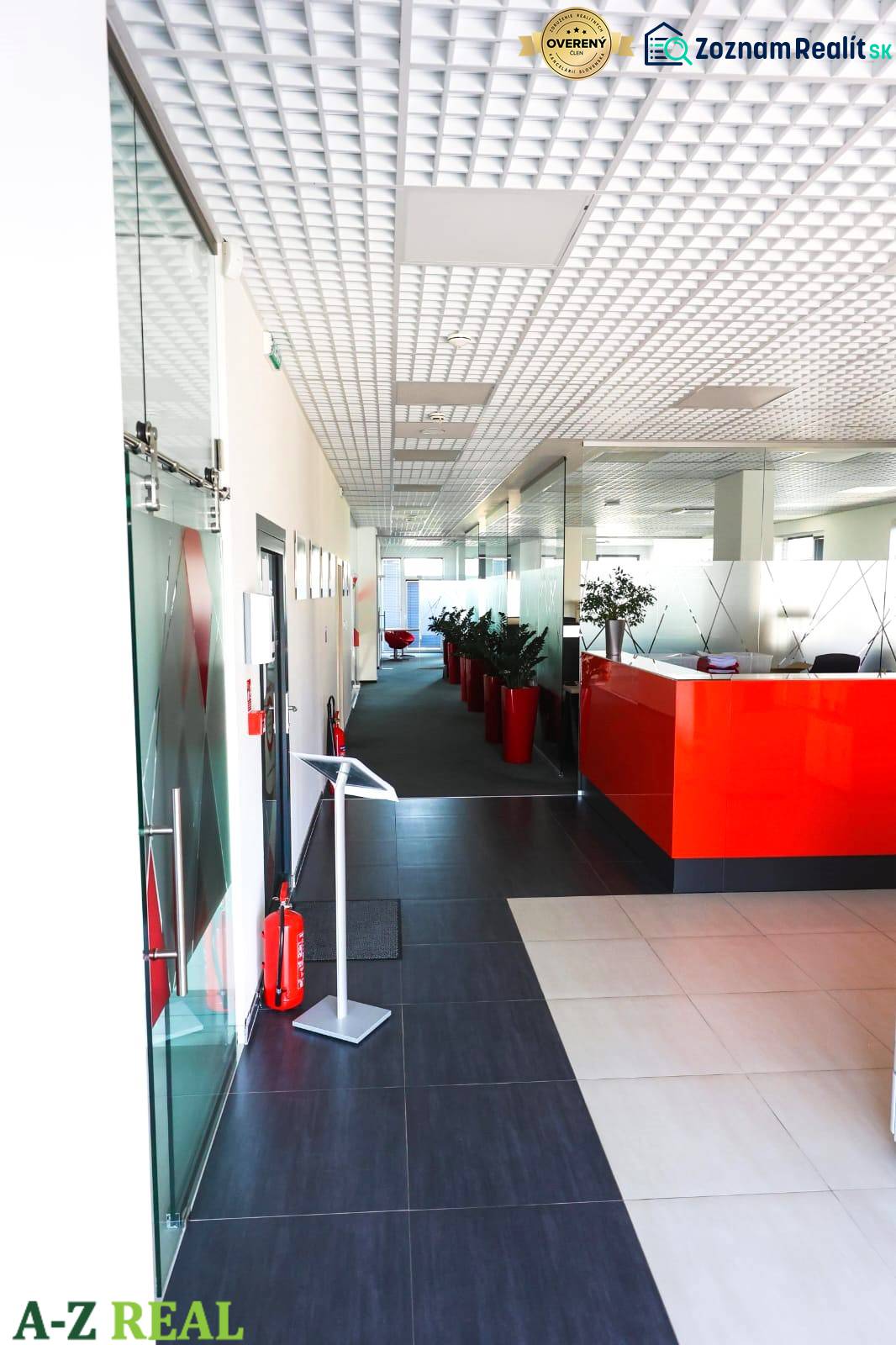 Prenájom kancelárií s TERASOU a výborným parkovaním, 264 m2, Ružinov - Chodba v kanceláriách s červenou recepciou, rastliny v červených kvetináčoch.