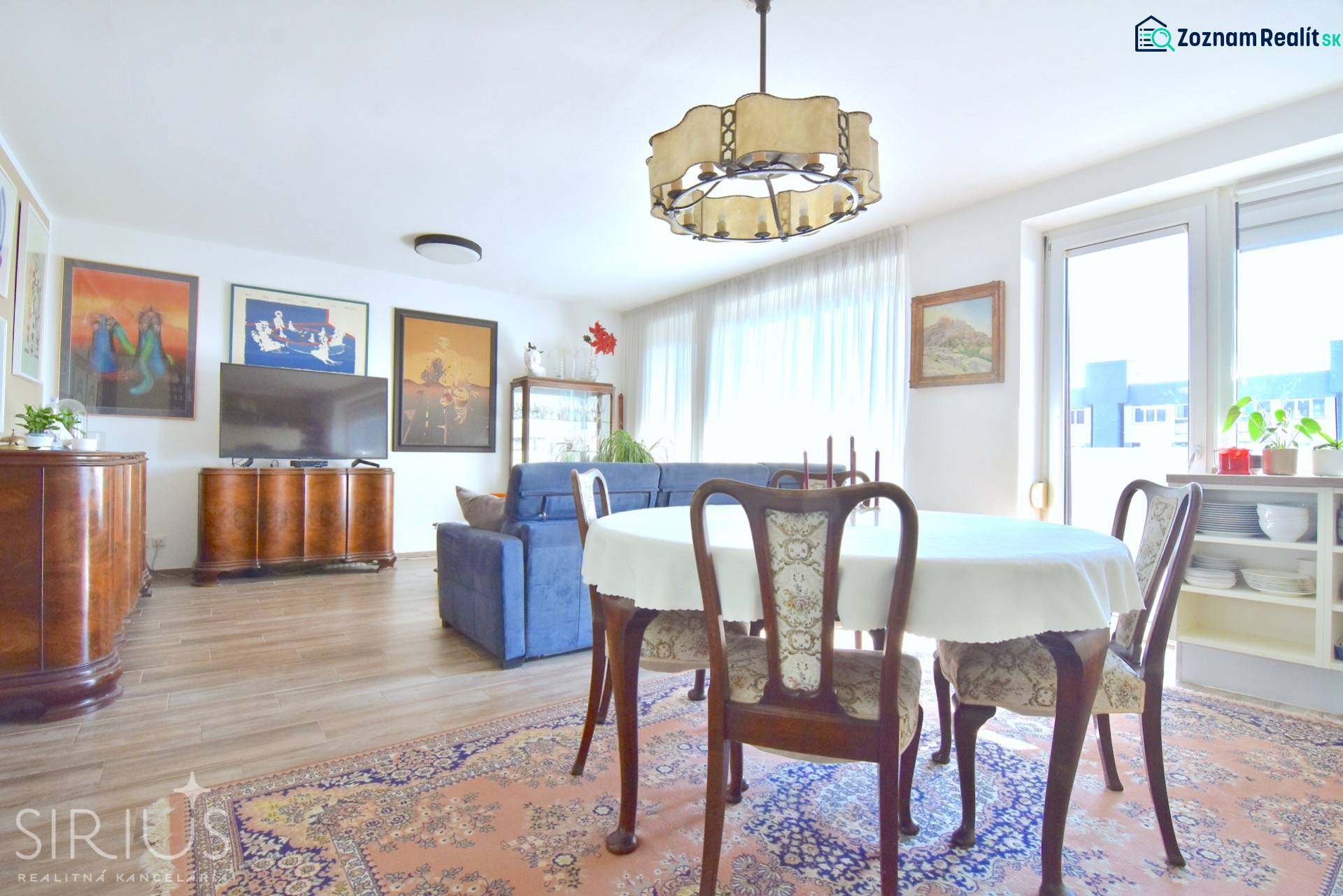 PRI VINOHRADOCH, 3-i byt s veľkými loggiami, 113 m2, RAČANY BIANCO - Obývacia izba s jedálenským stolom, pohovkou a podlahou s dreveným dekorom v 3-izbovom byte.