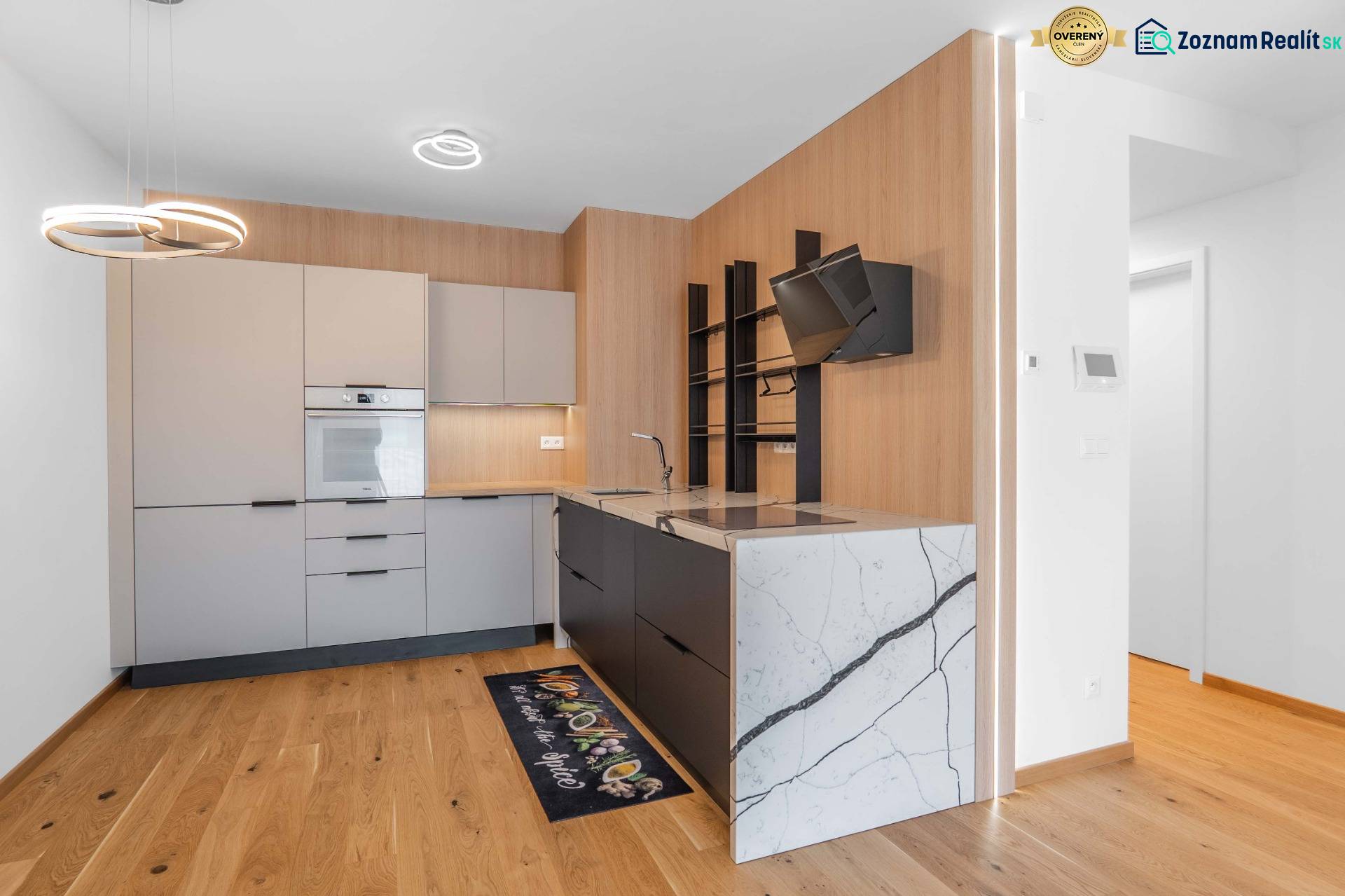 : Nadštandardný 2-i byt v projekte ZWIRN za cenu „štandardu“ - Kuchyňa v 2-izbovom byte s drevenou podlahou a modernými spotrebičmi.