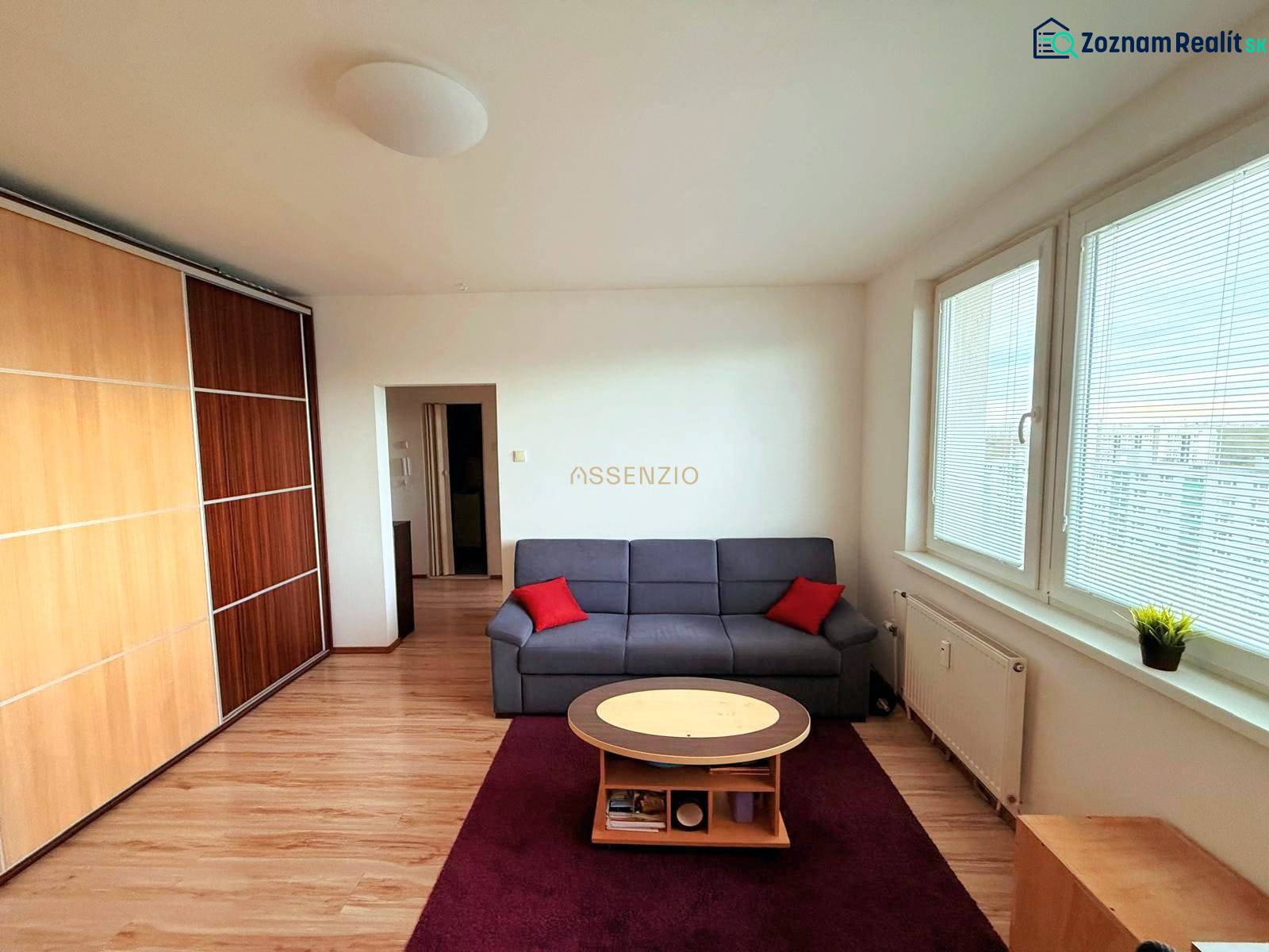 - PRENÁJOM - 1 IZBOVÝ BYT - TOPOĽČIANSKA UL. - PETRŽALKA - Obývačka v 1-izbovom byte s podlahou s dreveným dekorom a šatníkovou skriňou.