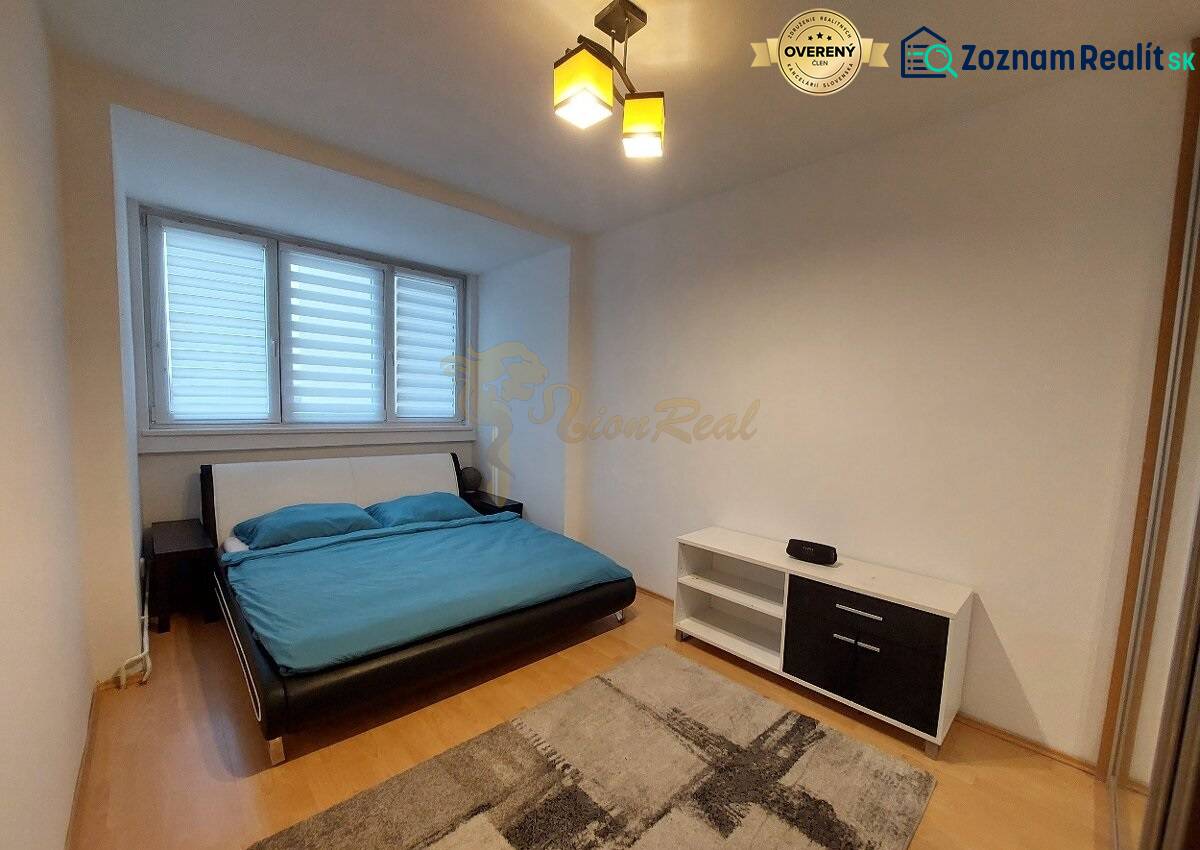 4-izb. byt na ul. Wolkrova, Petržalka, upravený na 2 bytové jednotky - Spálňa v 4-izbovom byte s podlahou s dreveným dekorom, posteľ a polica.
