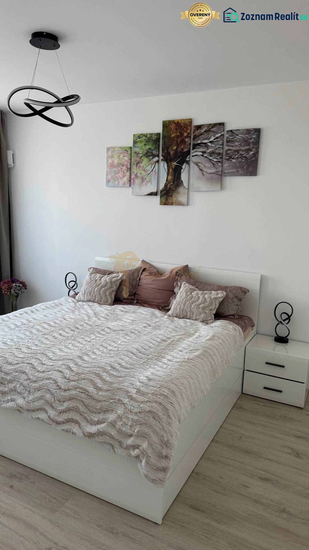 Novostavba 2,5-izb. bytu v NUPPU, garážové státie + vonkajšie státie - Spálňa s posteľou, nočnými stolíkmi a podlahou s dreveným dekorom v 2-izbovom byte.