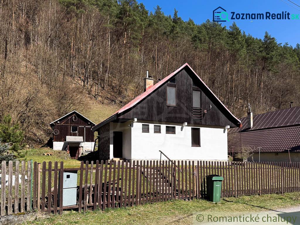 Chalupa - rodinný dom v krásnom prostredí – Moštenica, Banská Bystrica - Chata v Moštenici obklopená lesmi, oplotenie a odpadkový kôš na dvore.