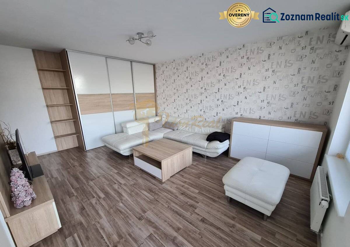 3-izb. byt, Nevädzová ul., Ružinov, Retro - Obývačka 3-izbového bytu s podlahou s dreveným dekorom, sedačkou a úložným priestorom.