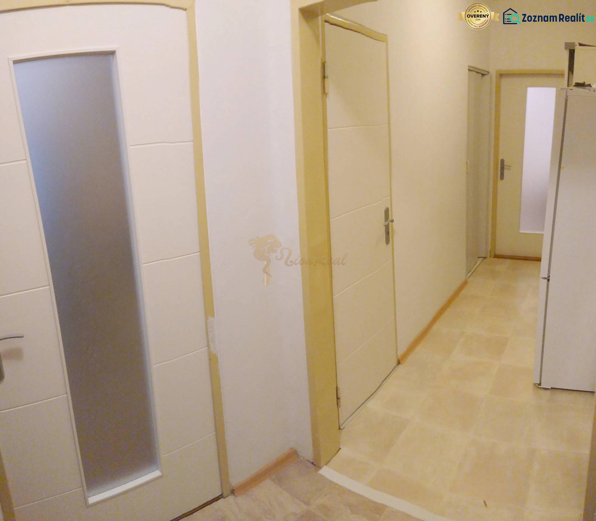 2-izb. byt pri Račianskom Mýte, balkón, 5.p./11 - Chodba v 2-izbovom byte s viacerými dverami a svetlou podlahou.