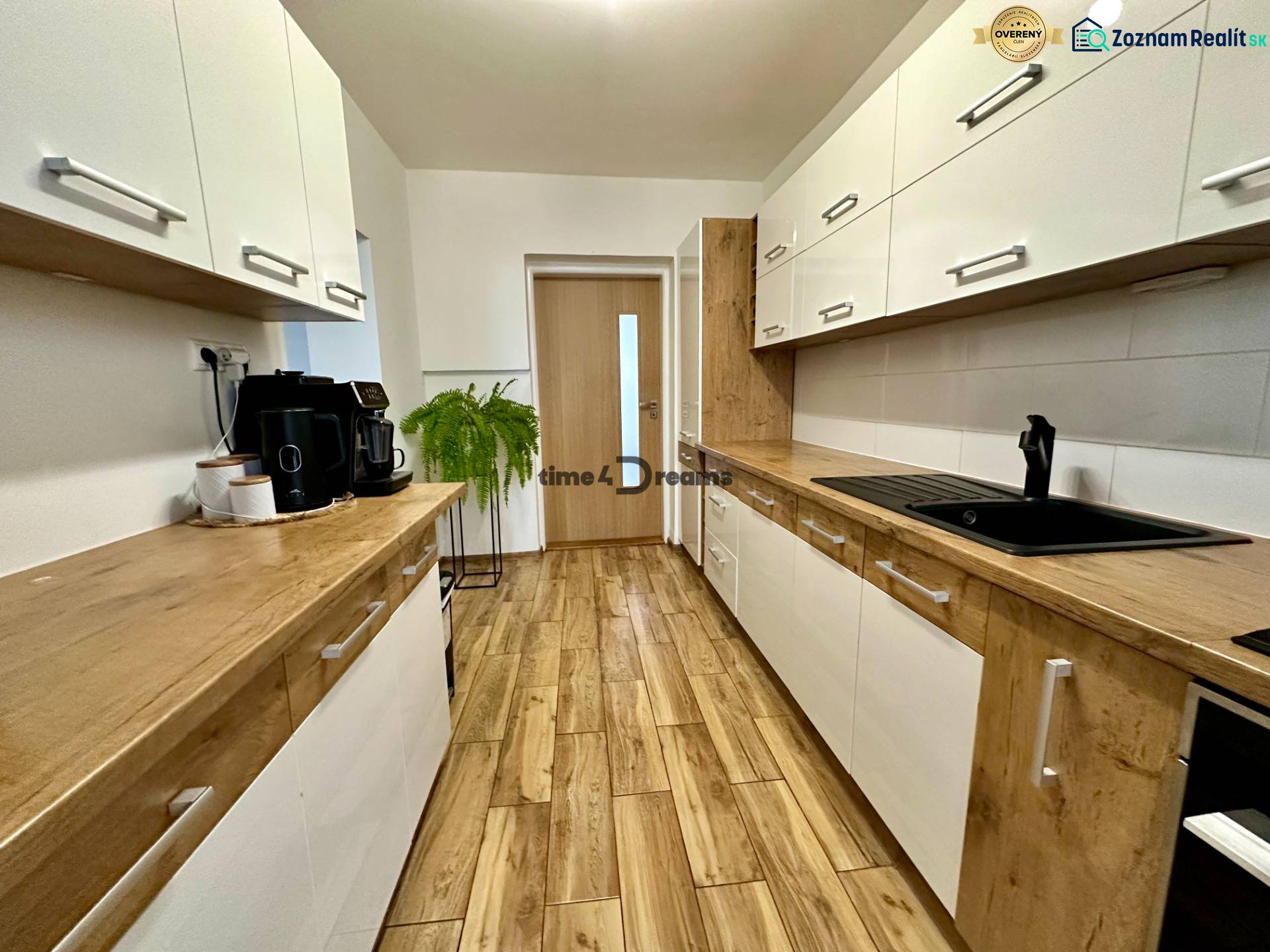 Na predaj: Priestranný rodinný dom v tichej lokalite obce Červeník - Kuchyňa v rodinnom dome s bielymi skrinkami a podlahou s dreveným dekorom.