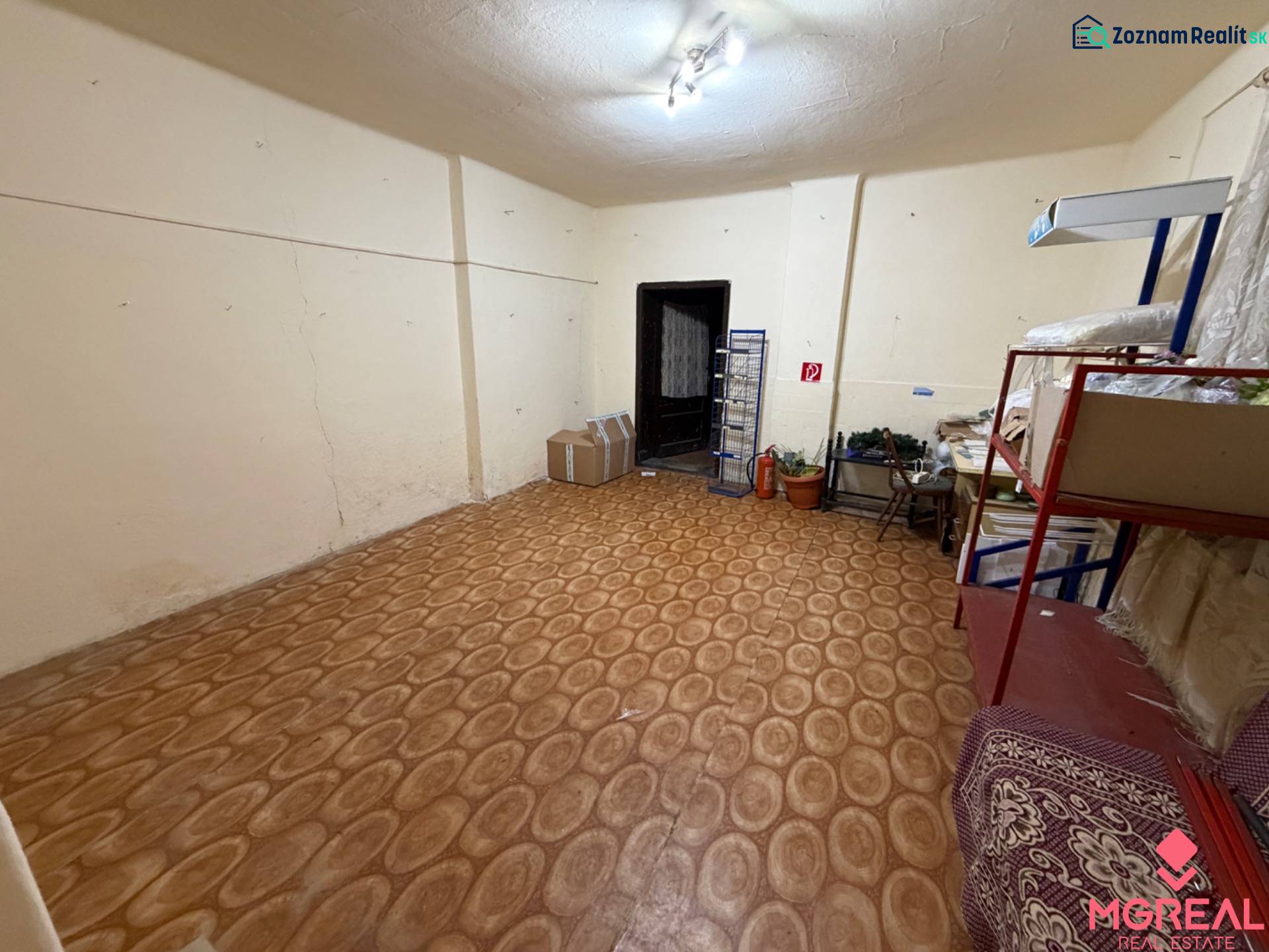Rodinný dom Horné Lefantovce - Miestnosť v rodinnom dome s policami, krabicami a podlahou s dreveným dekorom.