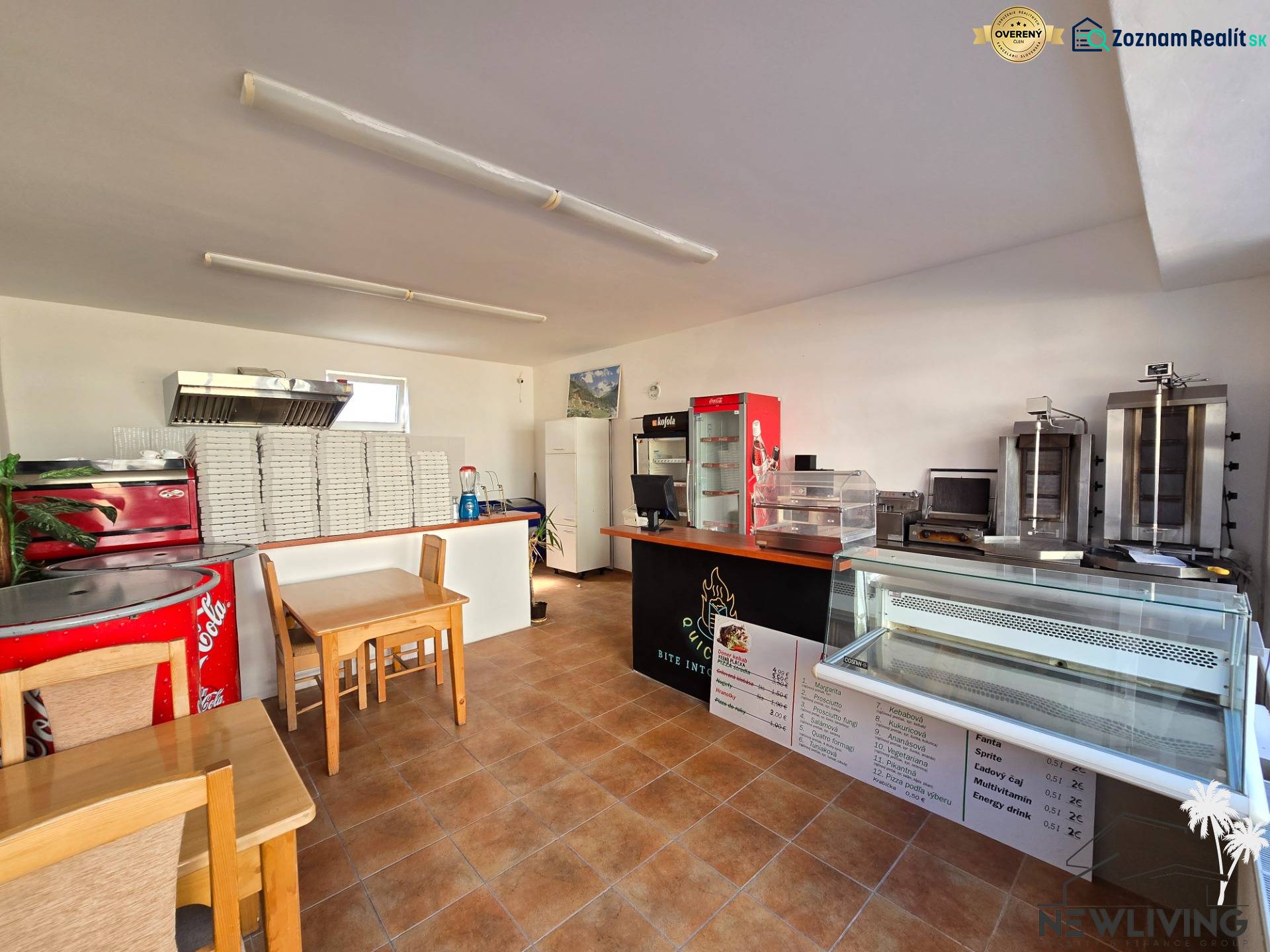 *NA PRENÁJOM* zariadená PIZZA / kebab - Mierová ul. - Interiér gastro priestorov s pultom, chladiacimi vitrínami a stohom krabíc na pizzu.