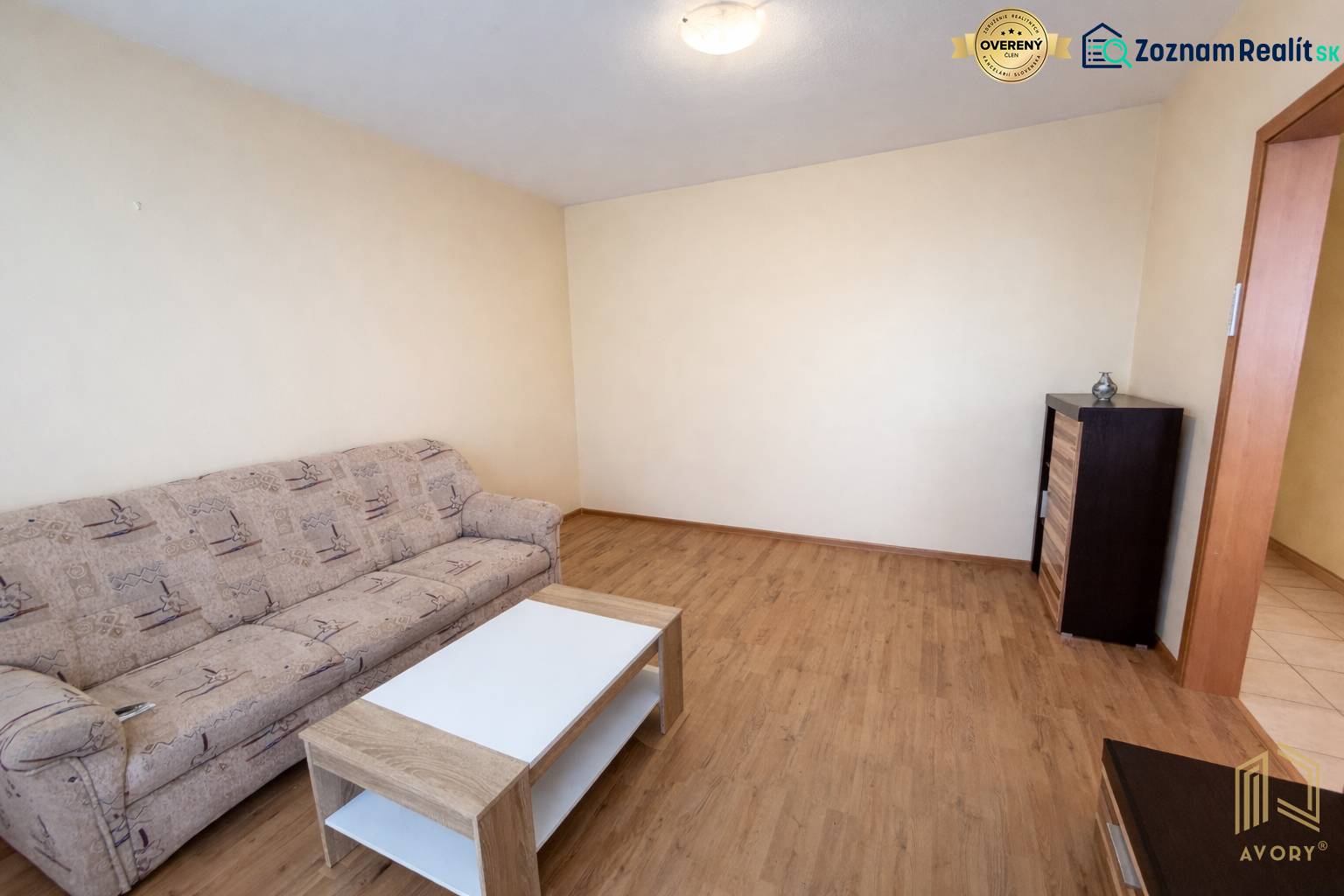 REZERVOVANÝ/ Na predaj 2-izb. byt s balkónom, Senica, Štefánikova ul. - Obývacia izba s pohovkou, stolíkom a podlahou s dreveným dekorom v 2-izbovom byte.