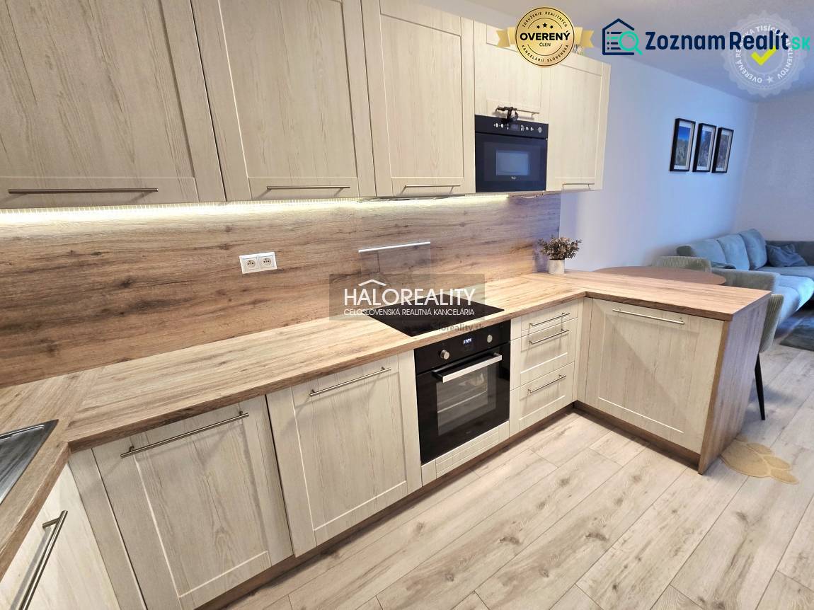 Predaj, dvojizbový byt Bratislava Podunajské Biskupi... - Kuchyňa s podlahou s dreveným dekorom v 2-izbovom byte, svetlé drevené skrinky a vstavané spotrebiče.