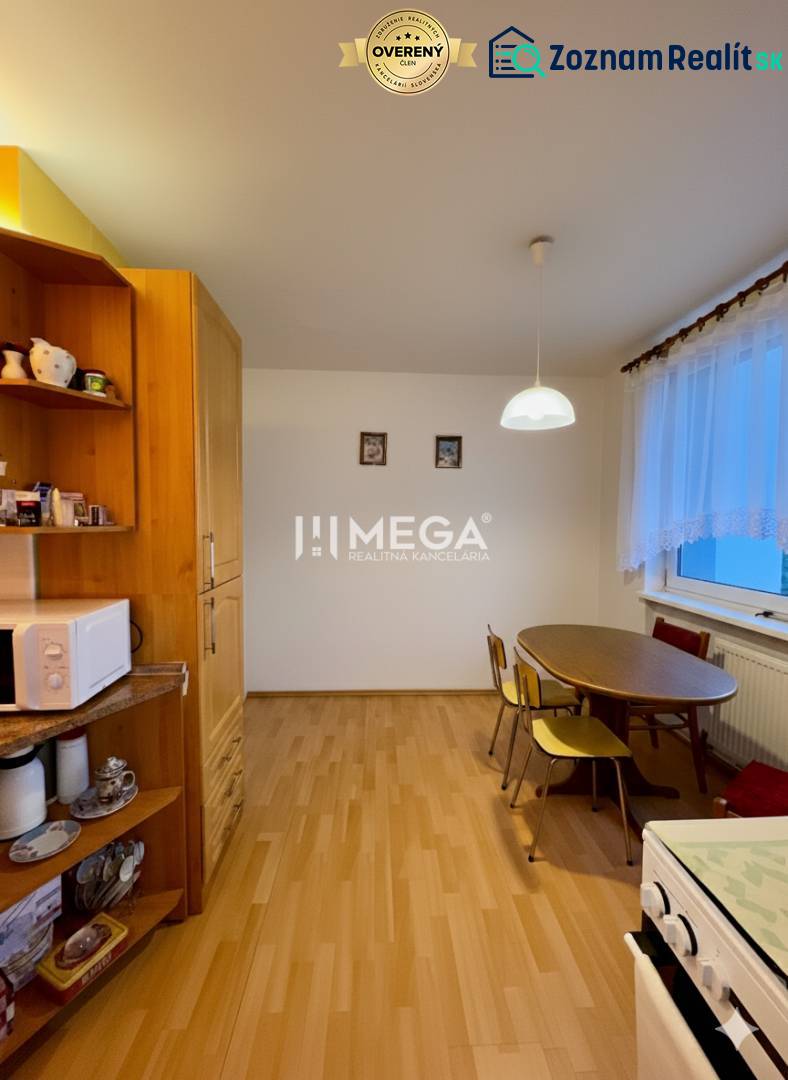 Na predaj veľký 3 izbový byt s balkónom v meste Humenné - Jedálenský kút so stolom a stoličkami v 3-izbovom byte, podlaha s dreveným dekorom.