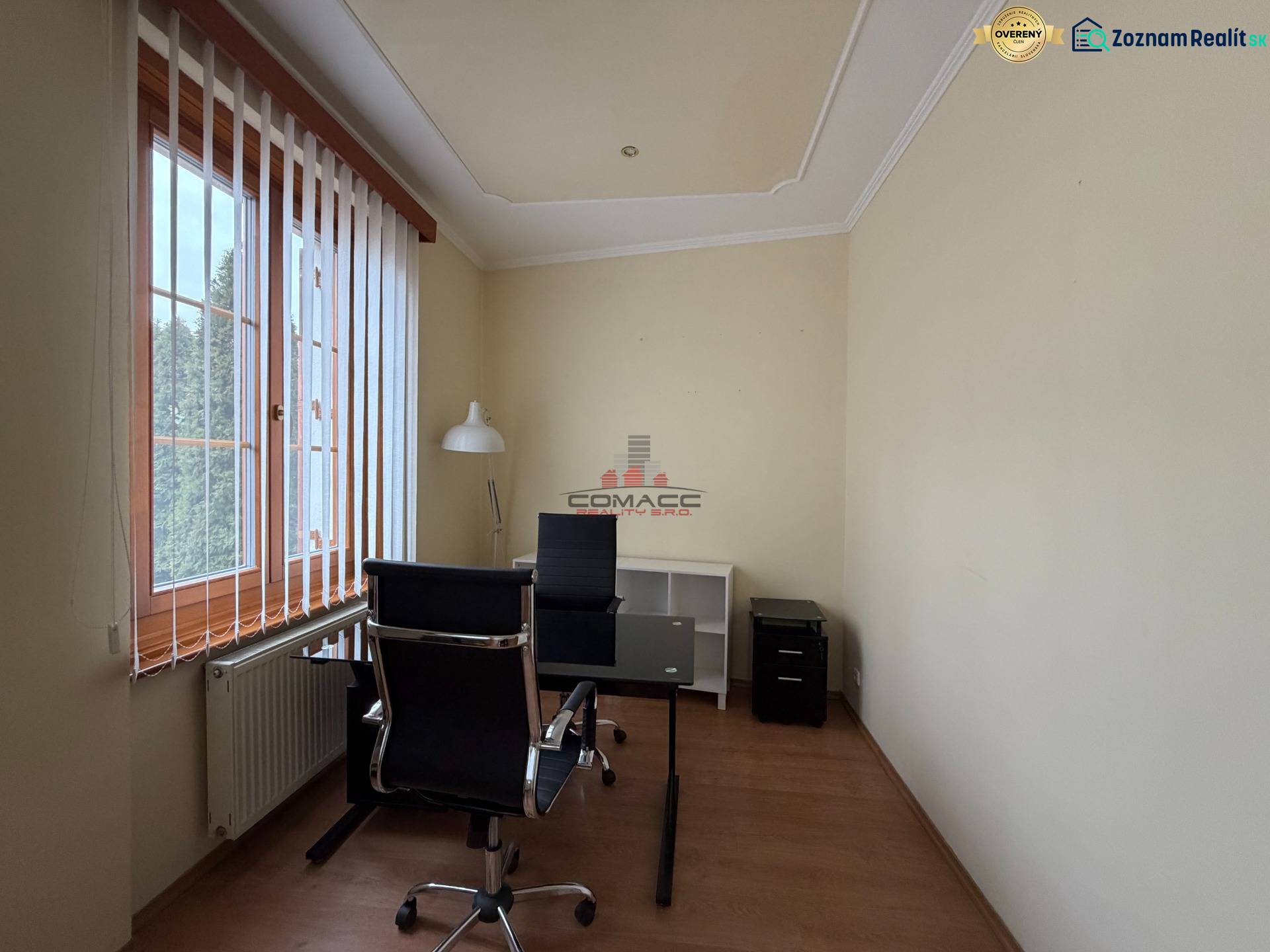 Prenájom kancelárie 33 m2 v centre Piešťan - Kancelárie s jedným stolom, stoličkou a svietidlom s dreveným dekorom podlahy.