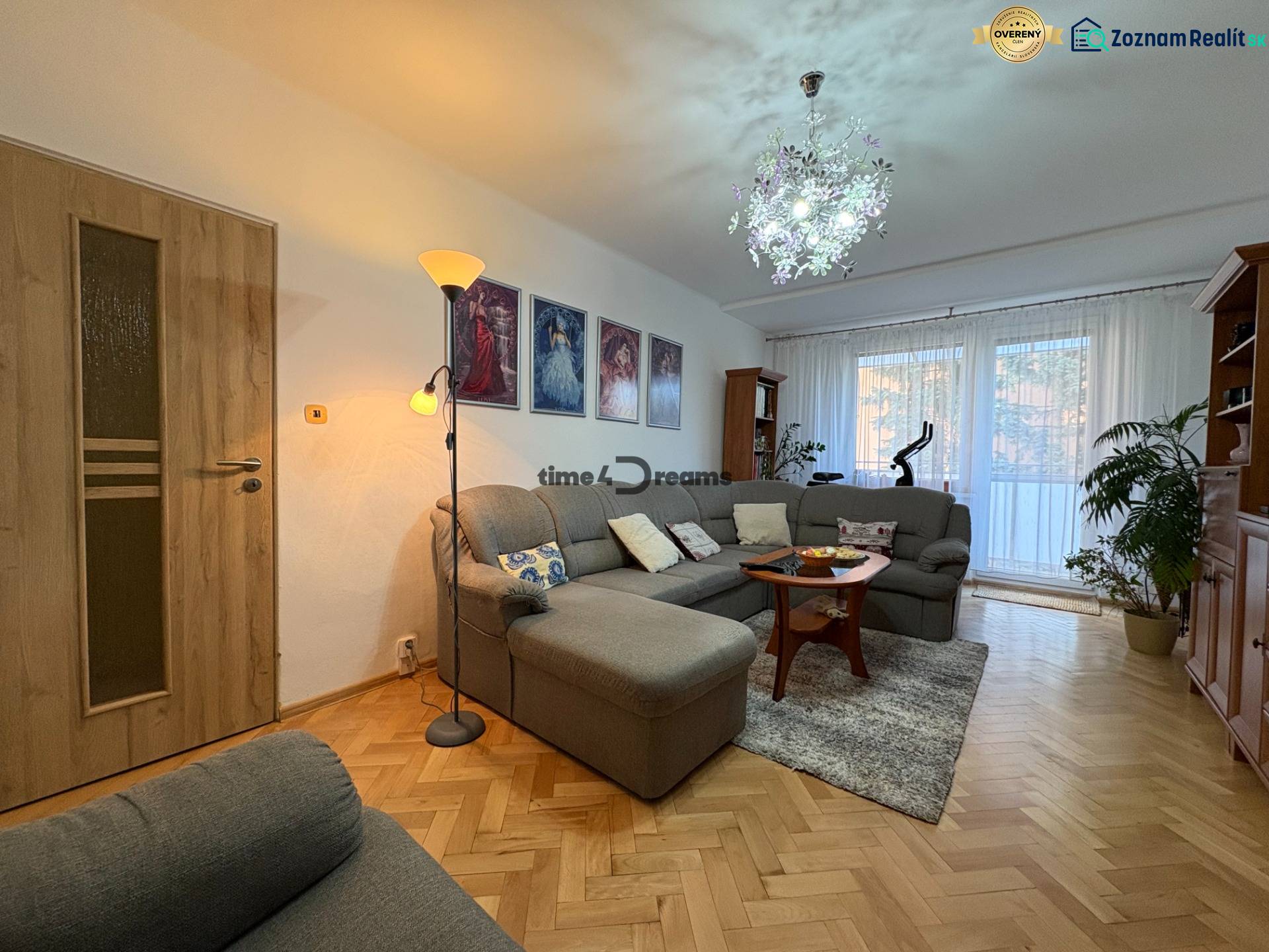 Na predaj: 4 izb.byt + BALKON + ŠATNIK + ŠPAJZA - Obývačka v 3-izbovom byte s pohovkou, rastlinami a podlahou s dreveným dekorom.