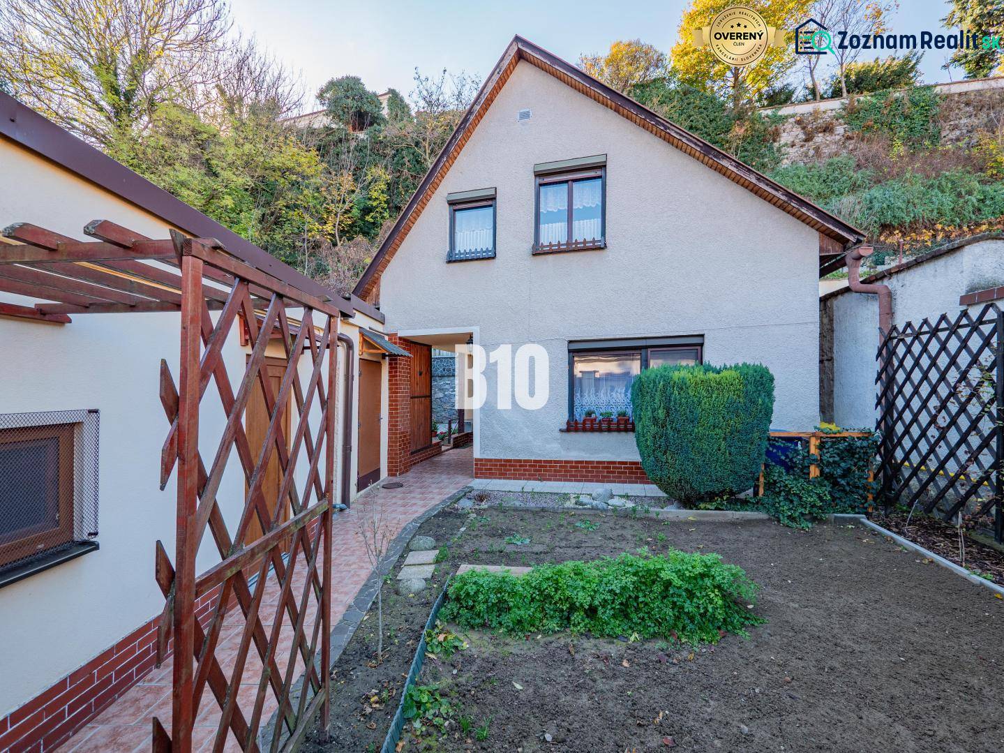 POD HRADOM bývanie alebo podnikanie - Rodinný dom v Nitre so záhradou, terasou a okrasnými kríkmi na svahu.