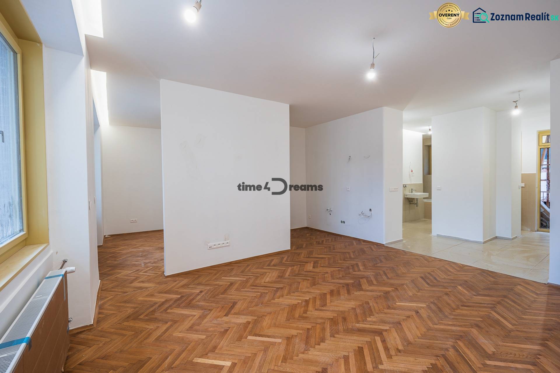 NA PREDAJ štýlový byt v centre Nitry  - Interiér s podlahou s dreveným dekorom a prázdnymi stenami v 3-izbovom byte.