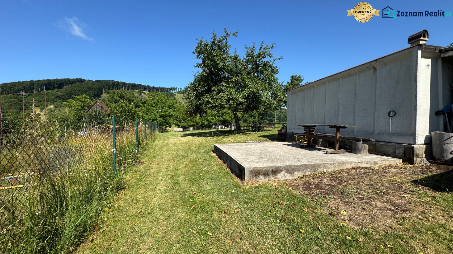 NA PREDAJ krásny pozemok pre váš nový Dom alebo Chalupu - Oplotený pozemok v Nová Baňa s trávou a stromami, ideálny na bývanie.