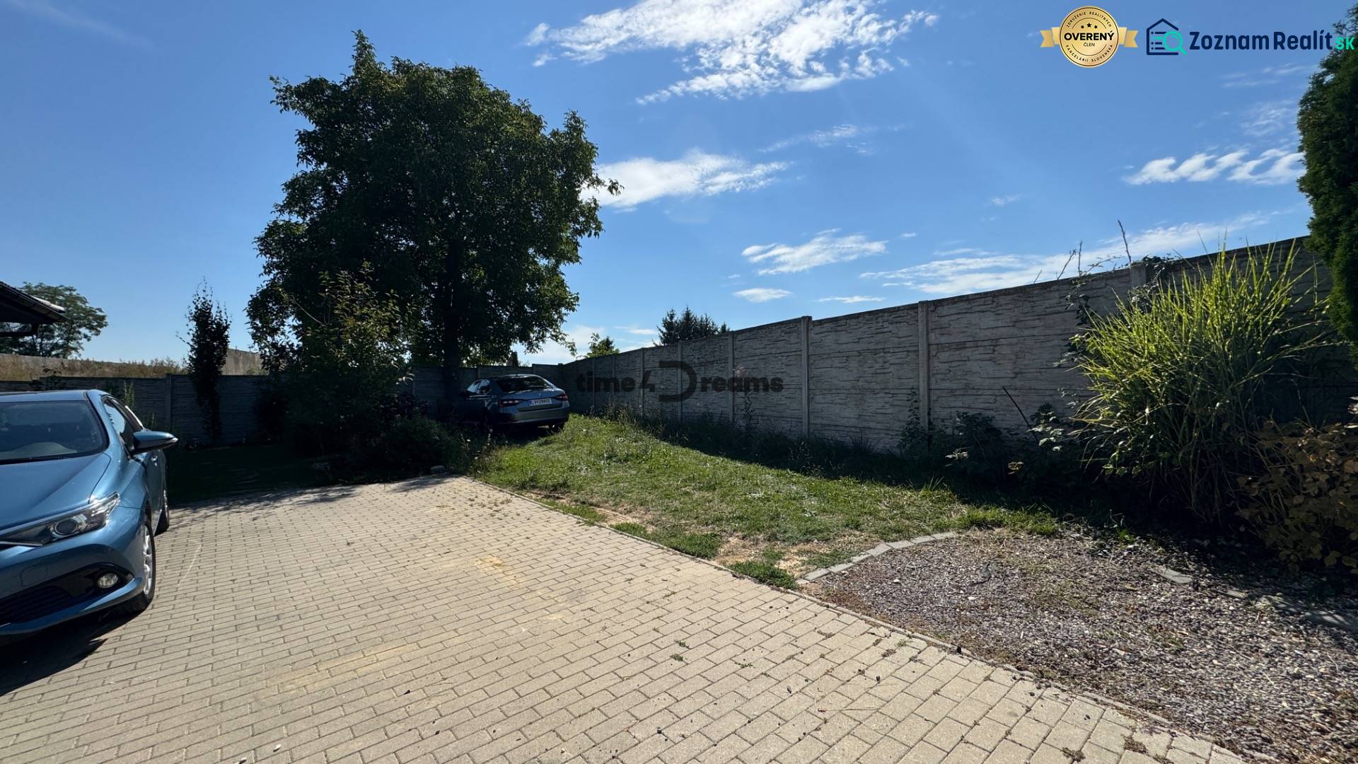 NA PREDAJ Radový rodinný dom v obci Malý Lapáš - Dvor rodinného domu v Malom Lapáši so spevnenou plochou a zeleňou pri múre.